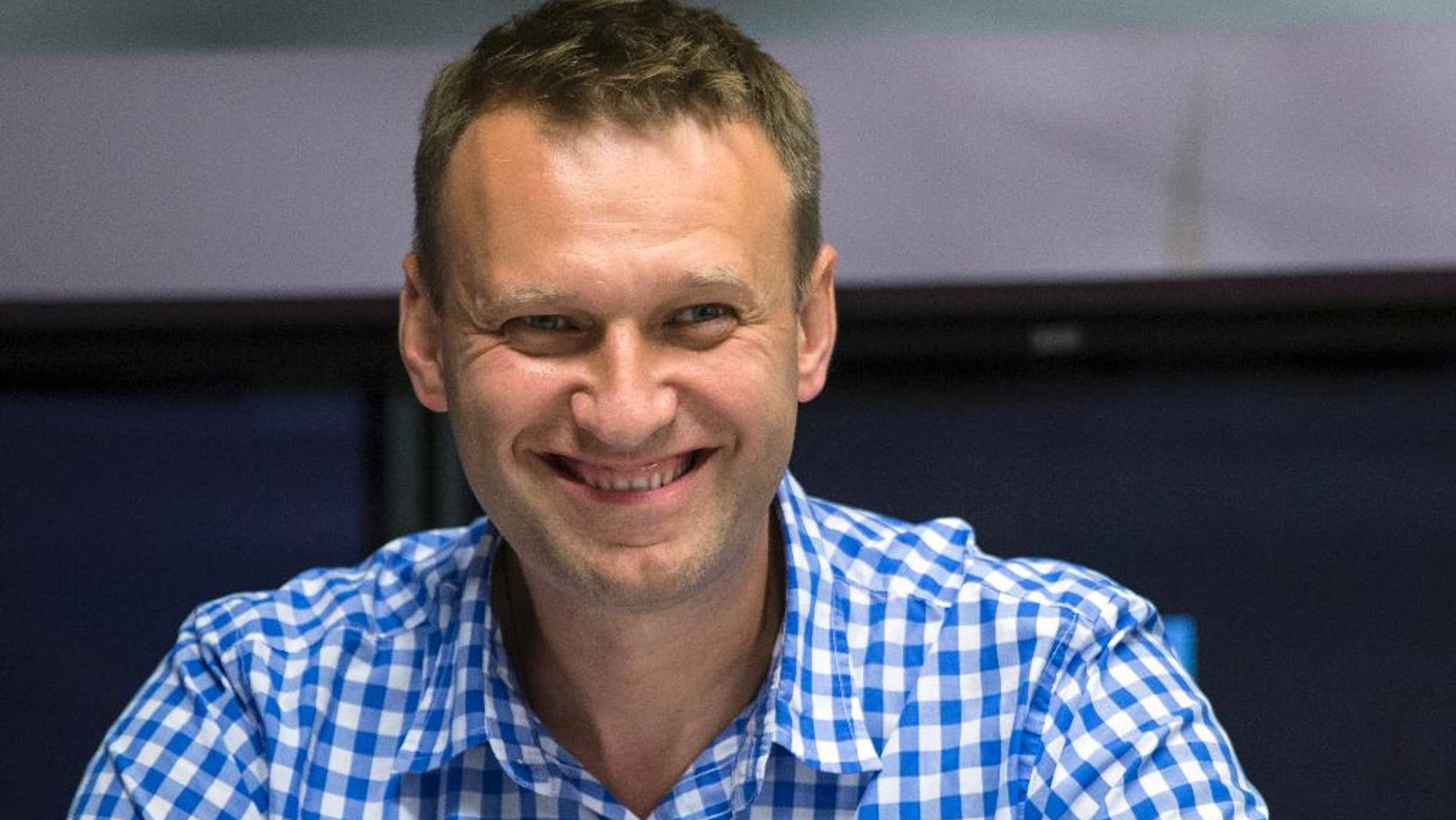 FILE - In this file photo taken on Wednesday, July 29, 2015, Russian opposition activist Alexei Navalny smiles before a broadcast at the Echo Moskvy (Echo of Moscow) radio station in Moscow. Russia's Supreme Court has sent a criminal case of the opposition leader for retrial following a ruling of the European Court of Human Rights. (AP Photo/Pavel Golovkin, FILE)