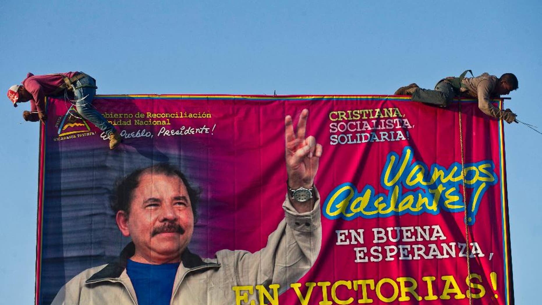 FILE - In this Dec. 21, 2015 file photo, workers install a billboard supporting Nicaragua's President Daniel Ortega along a street Managua, Nicaragua. The banner's message reads in Spanish: "Let's move ahead! In good hope, in victories!" The Supreme Electoral Council unseated 16 opposition legislators from the Liberal Independent Party and its ally the Sandinista Renovation Movement Friday, July 29, 2016, for not recognizing their leader. That leader, Pedro Reyes, had recently been given that authority by the Supreme Court, which removed the party’s previous leader following a long-running political dispute. Reyes is seen by some within his own party as a tool of Ortega. (AP Photo/Esteban Felix, File)