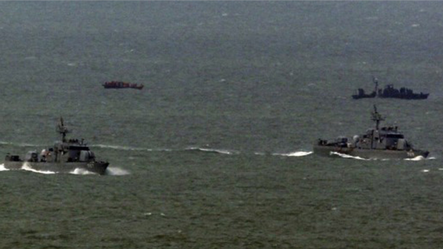 March 27: South Korean naval patrol ships (front) sail as a North Korean naval patrol ship (back R) approaches a repatriated North Korean fishing boat (back L) in the sea off South Korea's Yeonpyeong Island