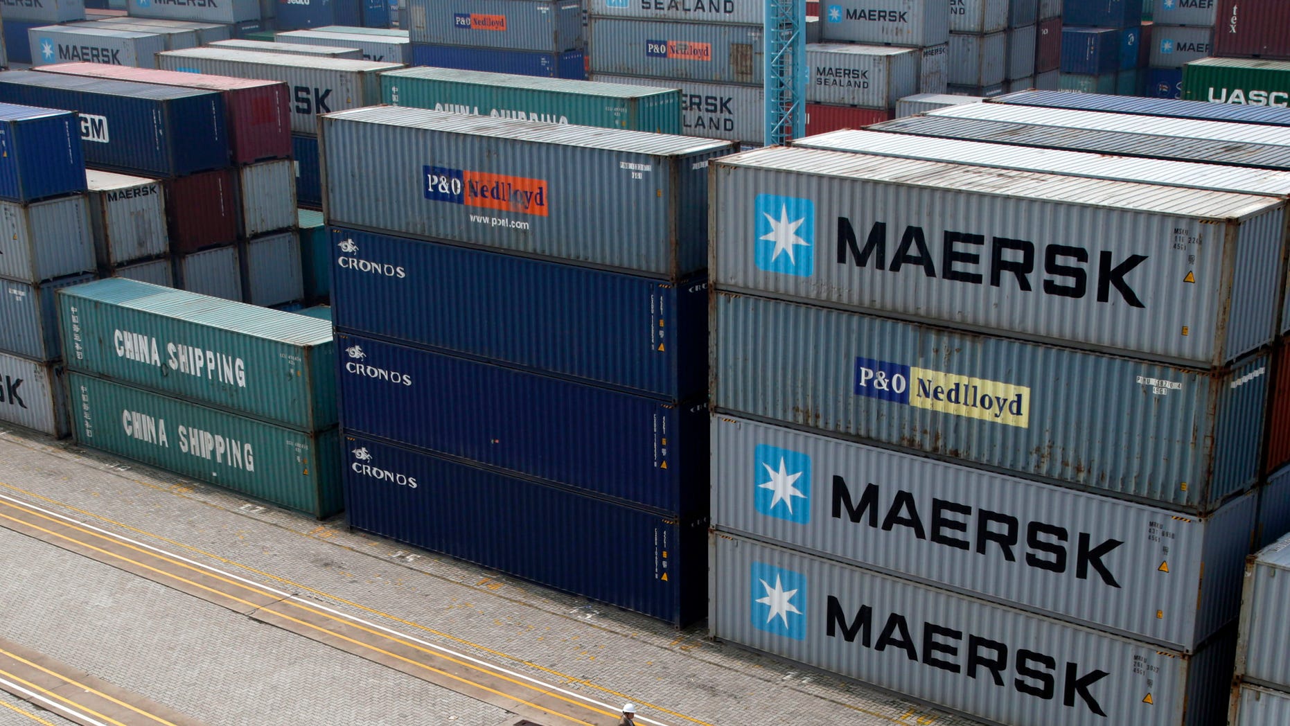 A worker walks past shipping containers piled at a port in Ningbo in east China's Zhejiang province, Tuesday, April 9, 2013. China reported higher import growth in March on Wednesday, April 10, 2013 in a possible positive sign for its economic recovery but analysts said doubts about the accuracy of Beijing's data made it hard to draw conclusions. (AP Photo) CHINA OUT