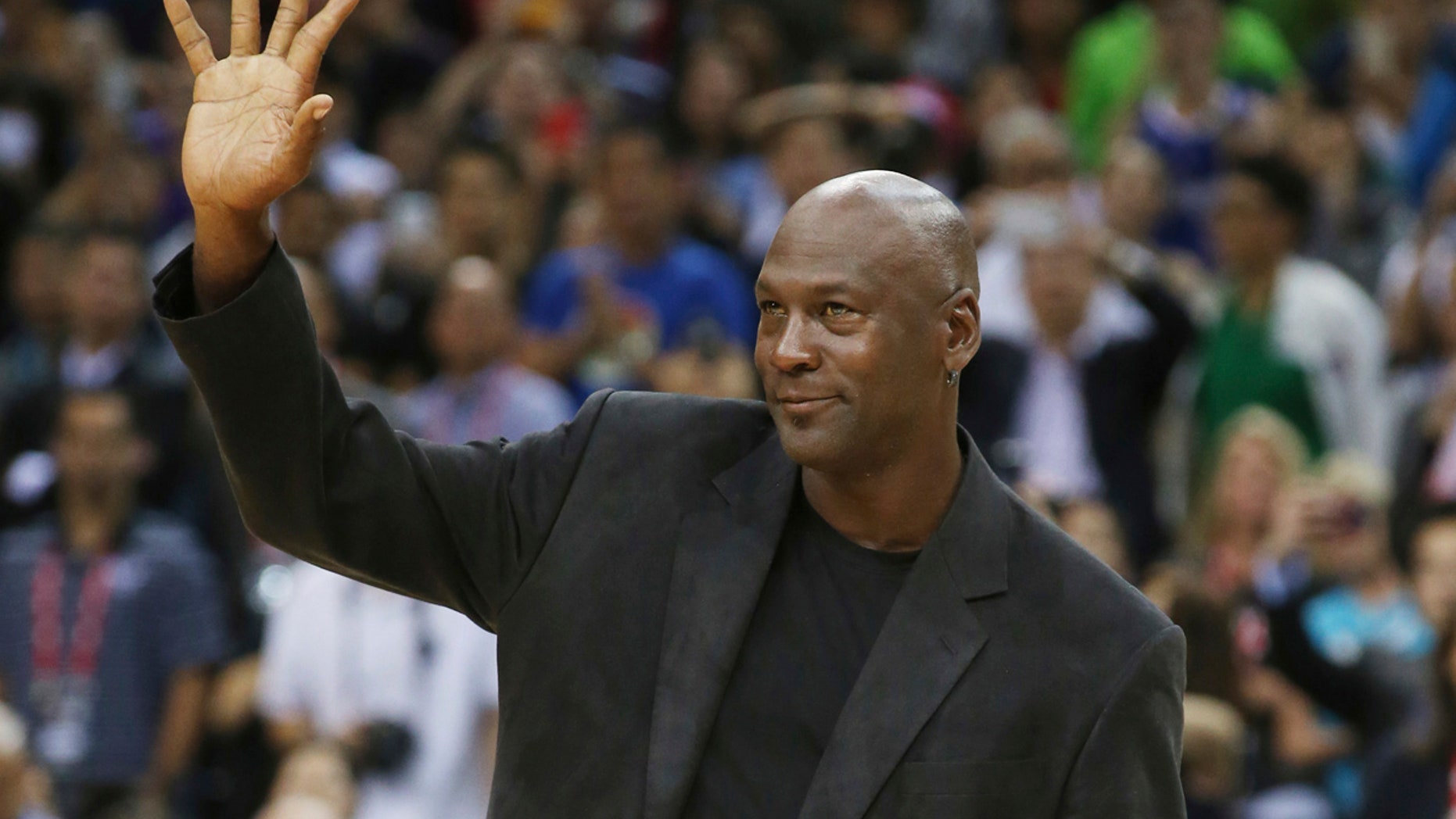 FILE - In this Oct. 11, 2015 file photo, NBA basketball legend Michael Jordan waves during the match of Charlotte Hornets against the Los Angeles Clippers at the 2015 NBA Global Games in Shenzhen, south China's Guangdong province.