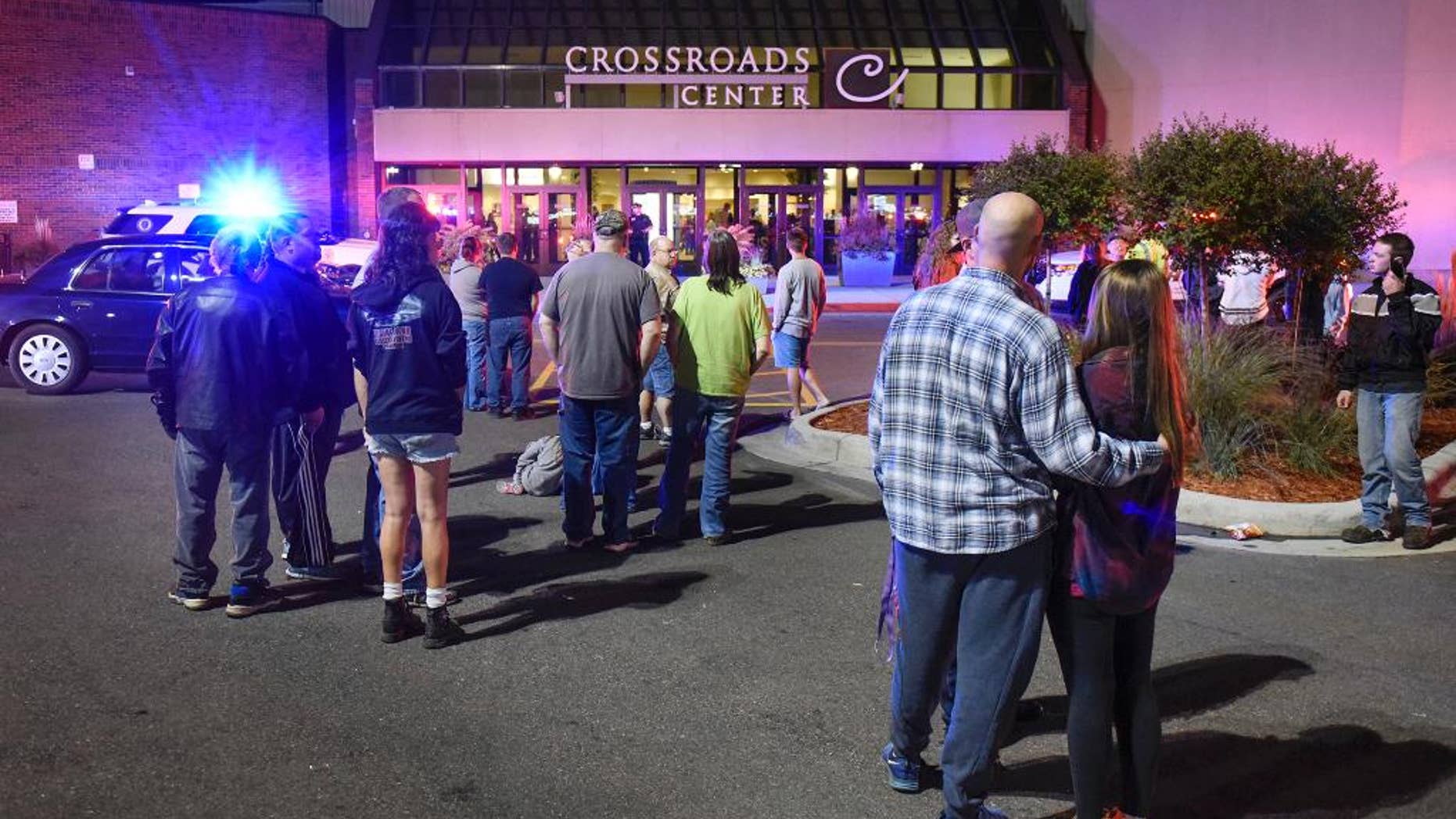FILE - In this Sept. 17, 2016, file photo, people stand near an entrance of Crossroads Center shopping mall in St. Cloud, Minn., after several people were stabbed. FBI Director James Comey said Wednesday, Sept. 28, 2016, that the man who stabbed multiple people in the mall before being shot and killed appears to have been inspired, at least in part, by extremist ideology. (Dave Schwarz/St. Cloud Times via AP File)