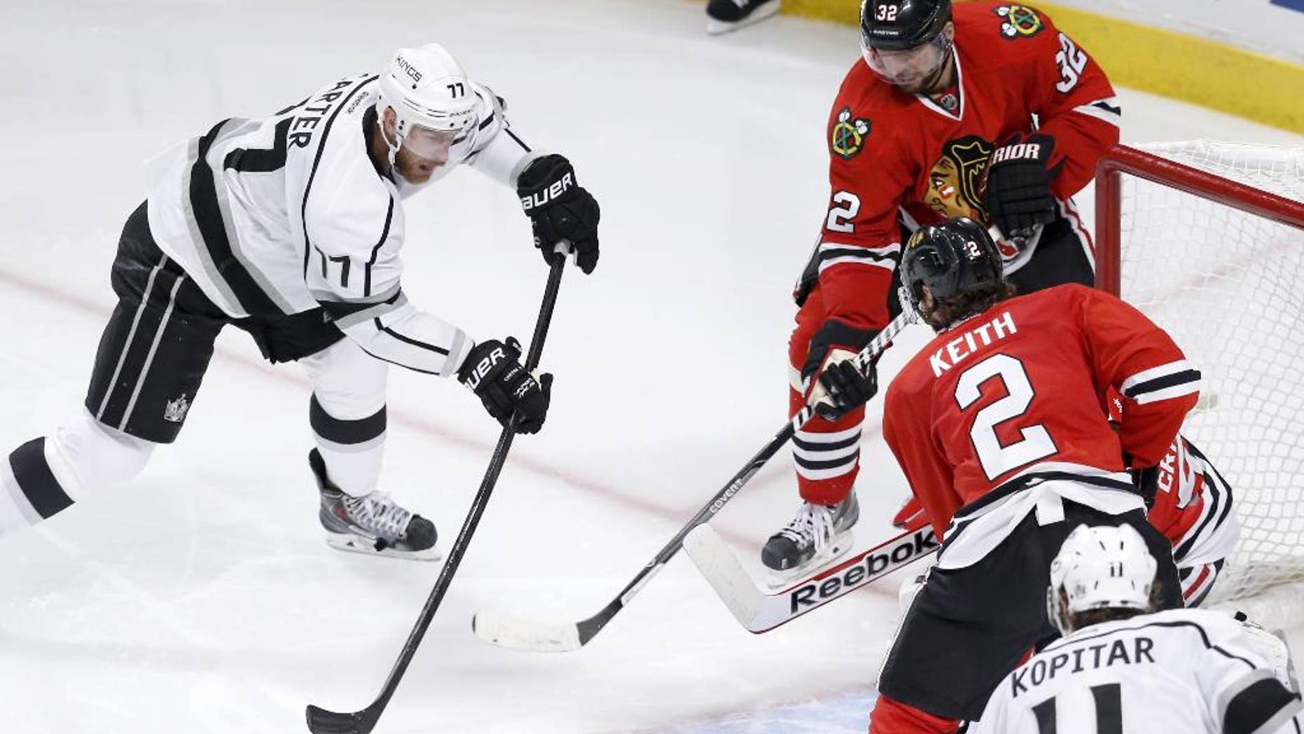 Los Angeles Kings center Jeff Carter shoots, but is unable to score past a defensive wall of Chicago Blackhawks' Michal Rozsival (32) Corey Crawford and Duncan Keith, during the third period of Game 1 of the Western Conference finals in the NHL hockey Stanley Cup playoffs in Chicago. The Blackhawks' defense is playing a key role in this postseason run as the Kings found out how hard it is to score on the defending Stanley Cup champions. (AP Photo/Charles Rex Arbogast)