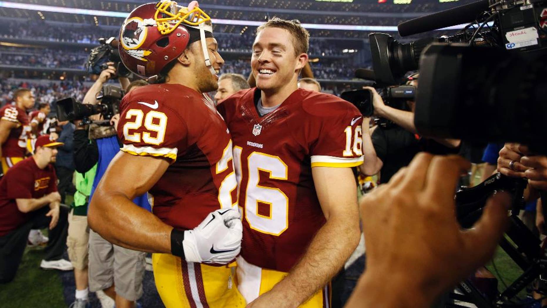 Washington Redskins' Roy Helu (29) and quarterback Colt McCoy (16) celebrate after an NFL football game against the Dallas Cowboys, Monday, Oct. 27, 2014, in Arlington, Texas. Washington won in overtime 20-17. (AP Photo/Tim Sharp)