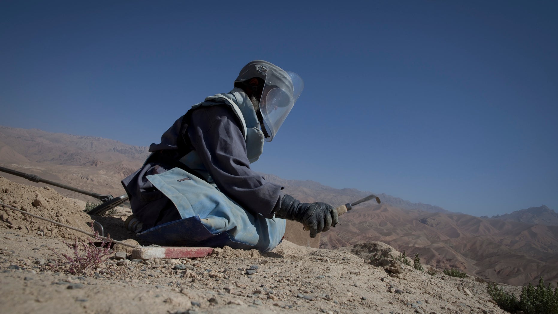 BAMIYAN, AFGHANISTAN - SEPTEMBER 2 : An Afghan deminer digs searching for mines and other munitions on top the archaelogical site of Shahr-i-Gholghola September 2 , 2009 in Bamiyan, Afghanistan. Afghan Technical Concultants (ATC) and the UN Mine Action center are working together to clear the ancient preserved ruins in the Bamiyan area, the project started on May 5th and will finish on October 15. On Shahr-i-Gholghola, there are 5 teams of deminers with 10 people each working on the ruins that date back to the 11th century. Aid workers say tourism is one of the greatest economic hopes for reviving this isolated and archaeologically stunning part of Afghanistan, a region that has seen little infrastructure development even though Bamiyan is one of the safest parts of the country. (Photo by Paula Bronstein/Getty Images)