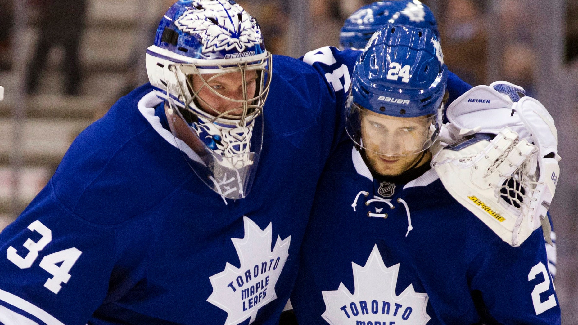Toronto Maple Leafs goaltender James Reimer (34) is helped off the ice by John-Michael Liles during the second period of their NHL hockey game against the Philadelphia Flyers, Monday, Feb. 11, 2013, in Toronto. (AP Photo/The Canadian Press, Chris Young)