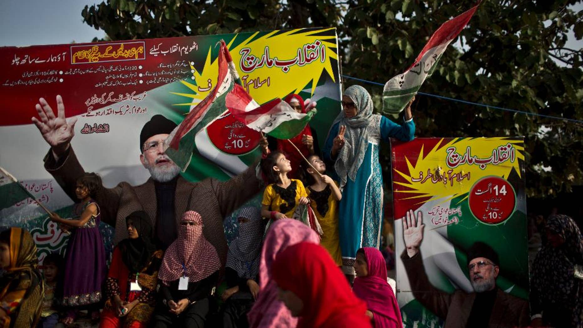 Supporters of fiery anti-government cleric Tahir-ul-Qadri, his images seen at background, take part in a protest, in Islamabad, Pakistan, Monday, Aug. 18, 2014. Qadri led massive rallies Saturday in Pakistan’s capital, demanding Prime Minister Nawaz Sharif step down over alleged fraud in last year’s election in front of thousands of protesters. (AP Photo/Muhammed Muheisen)