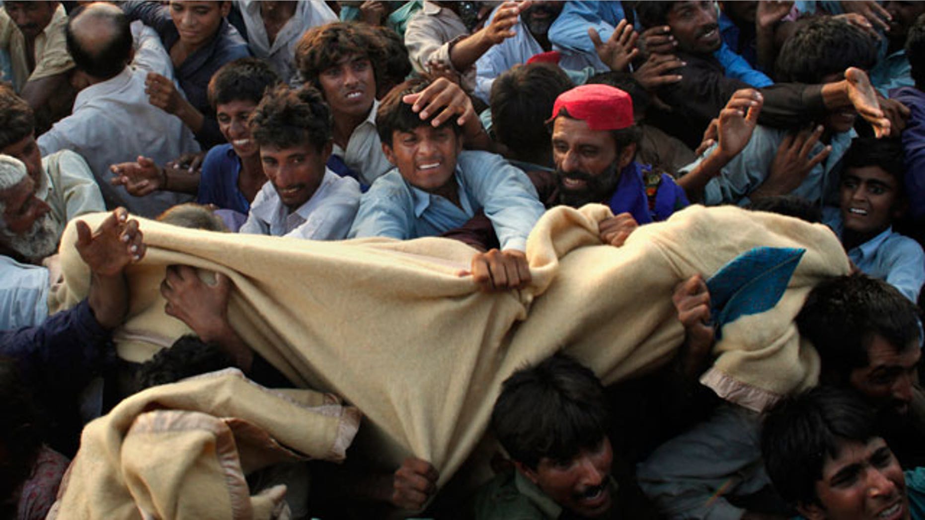 Pakistanis displaced by flooding fight for blankets during an aid distribution by the Pakistani Air Force at a temporary camp set up for residents who had to flee their homes in Sukkar, Sindh Province, southern Pakistan, Thursday, Aug. 19, 2010.