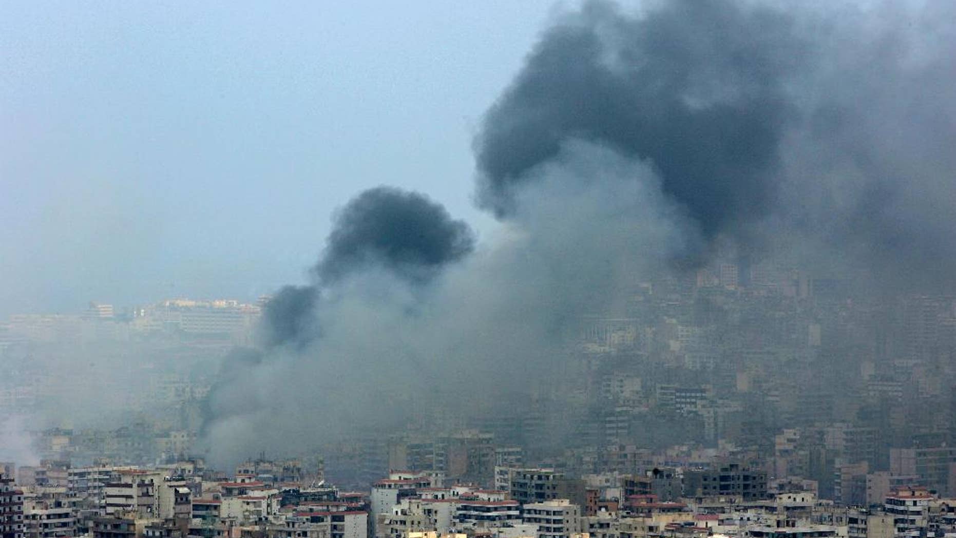 FILE - In this Sunday July 16, 2006 file photo, black smoke rises from the demolished headquarters of Hezbollah in the suburbs of Beirut, Lebanon, following Israeli air strikes. A top Israeli military leader on Wednesday April 20, 2016, issued a stern warning to the Lebanese militant group Hezbollah, saying any future war between the two enemies will unleash “devastating” damage on Lebanon. (AP Photo/Kevork Djansezian, File)