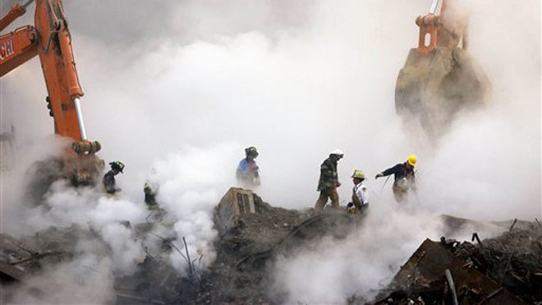 FILE - In this Oct. 11, 2001 file photo, firefighters make their way over the ruins and through clouds of smoke at the World Trade Center in New York. Many of the first responders and those who labored at the site in the months following the attacks suffer from a variety of respiratory ailments after working at the World Trade Center site. Nearly two years after President Obama signed the James Zadroga 9/11 Health and Compensation Act into law, about 60,000 responders and survivors continue to receive monitoring and treatment for their illnesses as part of the World Trade Center Health Program, one of the lawâs two components. (AP Photo/Stan Honda, Pool, File