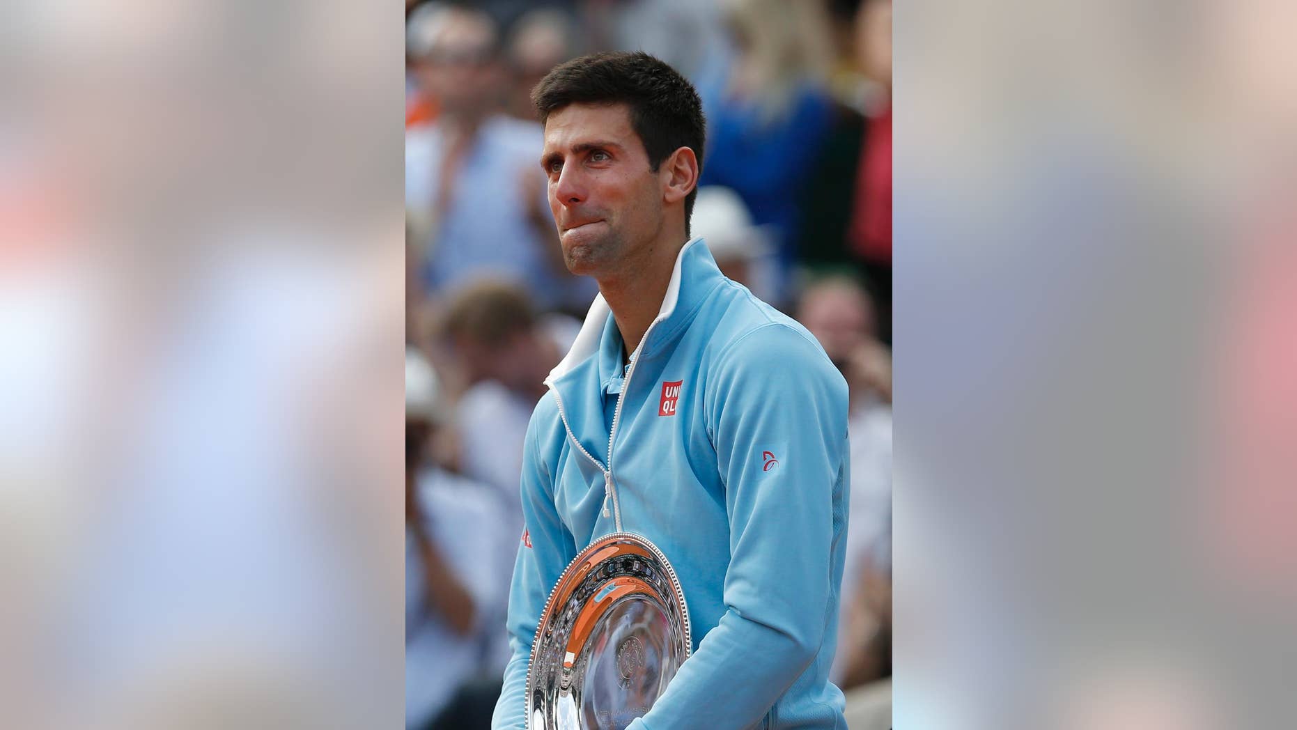 Serbia's Novak Djokovic holds the runner-up trophy after losing the final of the French Open tennis tournament against Spain's Rafael Nadal at the Roland Garros stadium, in Paris, France, Sunday, June 8, 2014. Nadal won in four sets 3-6, 7-5, 6-2, 6-4. (AP Photo/Darko Vojinovic)