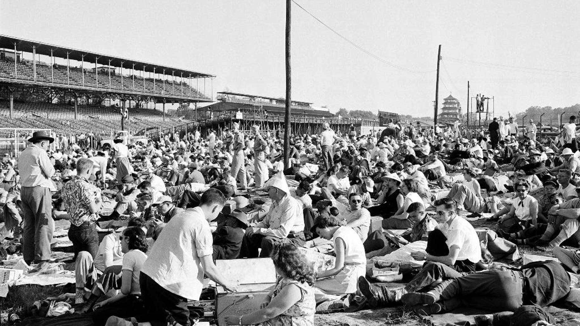 FILE - In this May 30, 1953, file photo, early arrivals at the Indianapolis Motor Speedway track lounge around on the grass in the infield of the oval Brickyard before the start of the 37th Indianapolis 500 auto race in Indianapolis, Ind. (AP Photo/File)