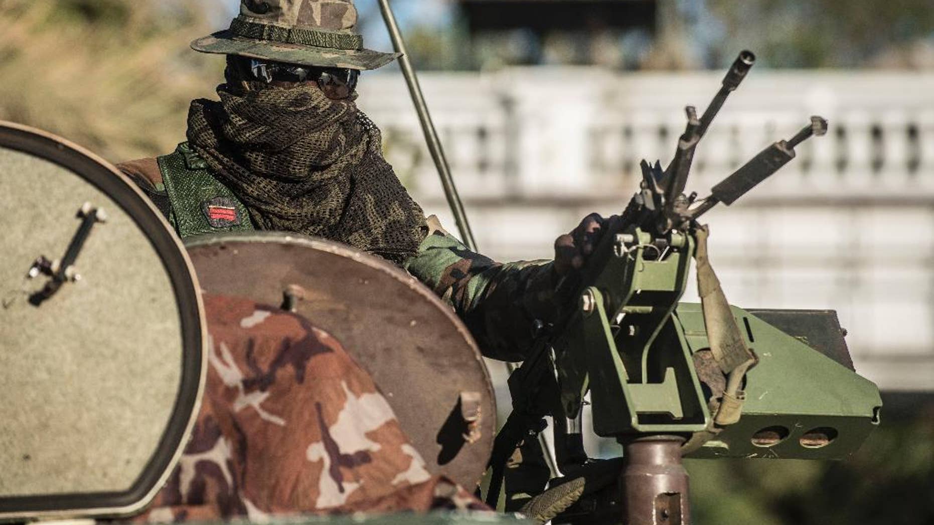 An ECOWAS Senegalese soldier guards the State House entrance in Banjul, Gambia, Wednesday Jan. 25, 2017. Gambia's new President Adama Barrow will arrive in the country on Thursday, a week after he was sworn into office in neighboring Senegal, officials with the new government confirmed Wednesday. (AP Photo/Sylvain Cherkaoui)