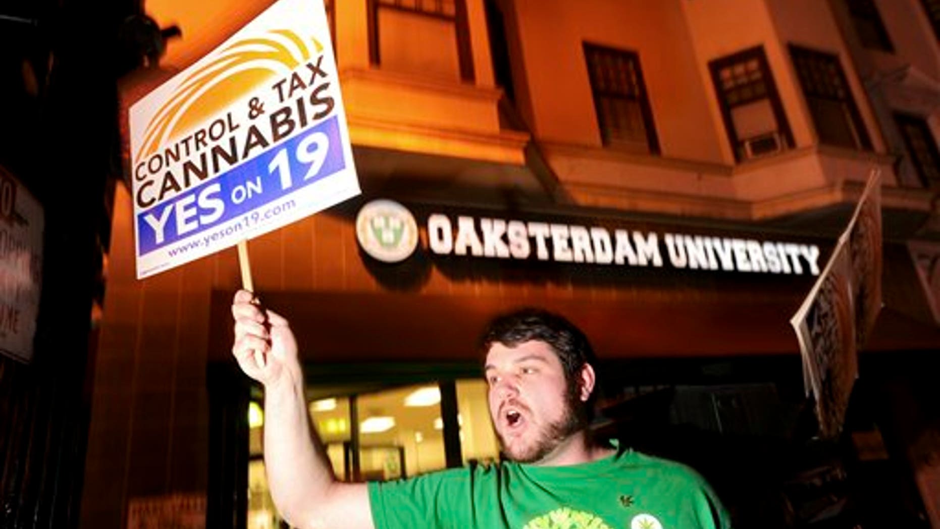 Daniel Costa, a volunteer with the campaign to legalize marijuana, rallies last minute voters to support Proposition 19 shortly before polls closed on Tuesday, Nov. 2, 2010, in Oakland, Calif. If passed, the California proposal would let adults possess up to an ounce of pot, consume it in private places as long as no children were present and grow it in small private plots. (AP Photo/Noah Berger)