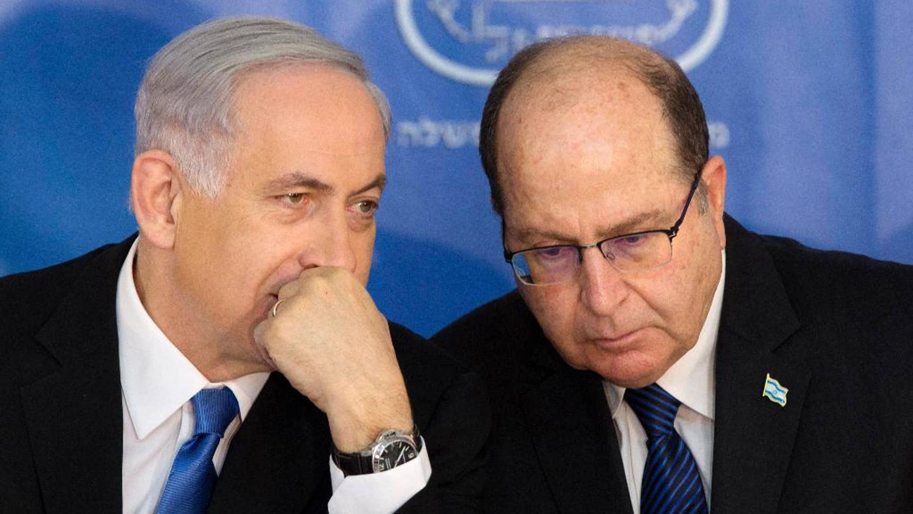FILE - In this Monday, Feb. 16, 2015 file photo, Israeli Prime Minister Benjamin Netanyahu, left, speaks with Israel's Defense Minister Moshe Yaalon during a ceremony for new Israeli Chief of Staff Gadi Eizenkot at the Prime Minister's office in Jerusalem. Israel's newly resigned defense minister has accused Prime Minister Benjamin Netanyahu of exaggerating the country's security threats to distract attention from other issues. (AP Photo/Sebastian Scheiner, File)
