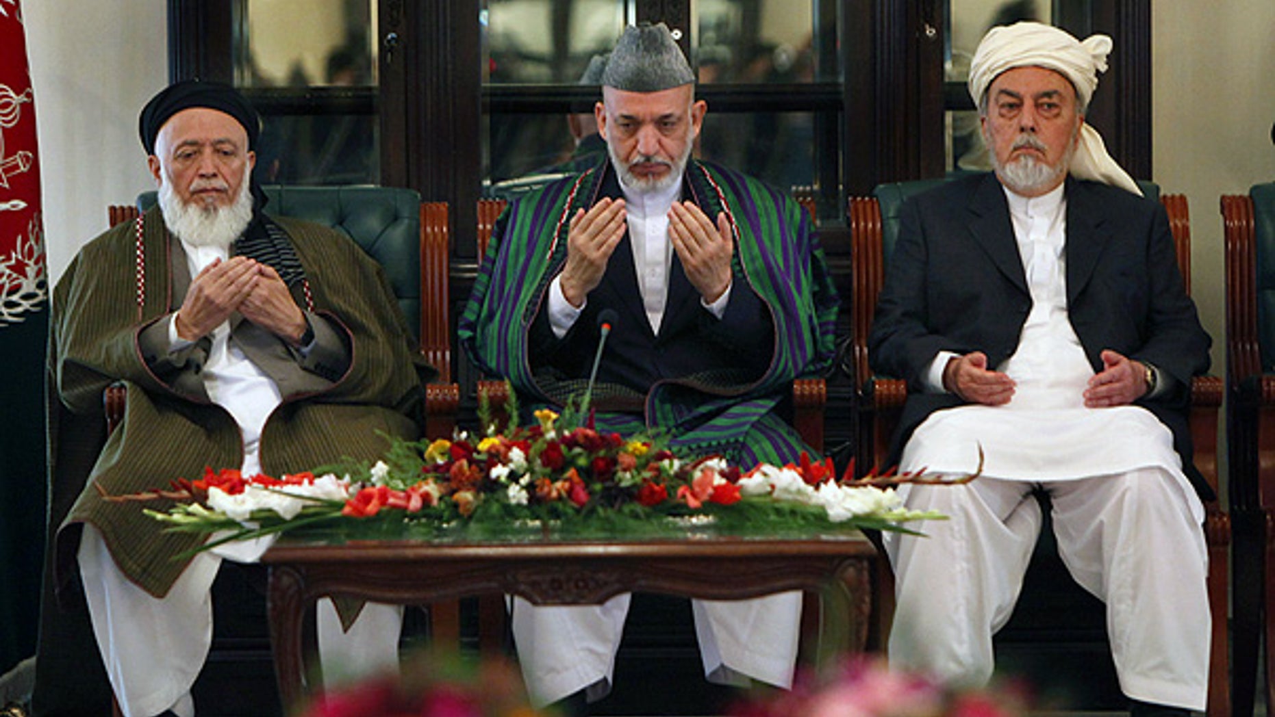 Oct. 7: Afghan President Hamid Karzai, center, prays with members of the Afghanistan peace council in Kabul.