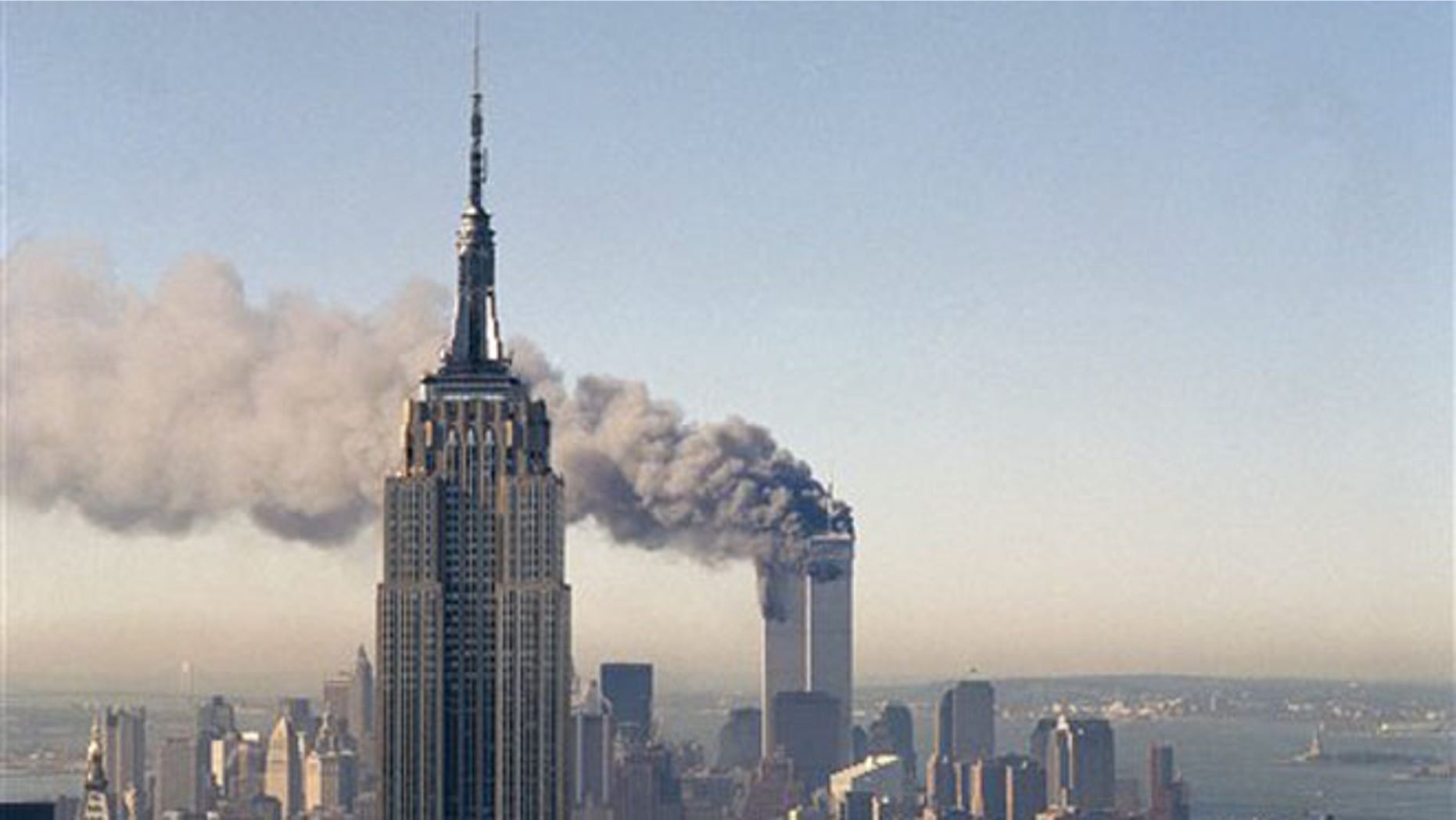 Sept. 11, 2001: In this file photo, the twin towers of the World Trade Center burn behind the Empire State Building in New York.
