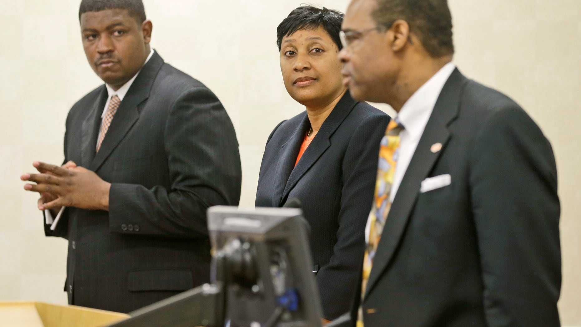 CORRECTS SCHOOL TO VIRGINIA STATE UNIVERSITY, NOT NORFOLK STATE UNIVERSITY, AND LOCATION TO ETTRICK, NOT PETERSBURG - Virginia State University head football coach, Latrell Scott, left, and athletic director, Peggy Davis, center, listen as VSU president Keith T. Miller, right, address a press conference at Virginia State University in Ettrick, Va., Monday, Nov. 18, 2013. School officials held the press conference to answer questions after Winston-Salem quarterback Rudy Johnson was beaten in a bathroom brawl Friday, Nov. 15 that led to VSU being banned from post season play. (AP Photo/Steve Helber)