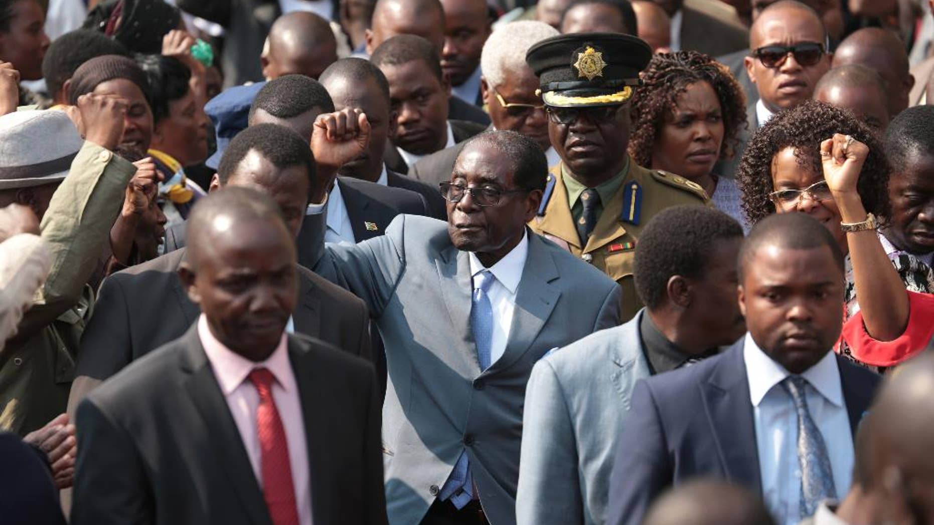 Zimbabwean President Robert Mugabe, centre, gestures after addressing members of the Zimbabwe National Liberation War Veterans Association, at the party headquarters, in Harare, Wednesday, July, 27, 2016. Zimbabwe's 92-year-old president on Wednesday said the longtime loyalists who turned against him last week should face "severe" punishment, and he vowed to stay in power for "a long time." (AP Photo/Tsvangirayi Mukwazhi)