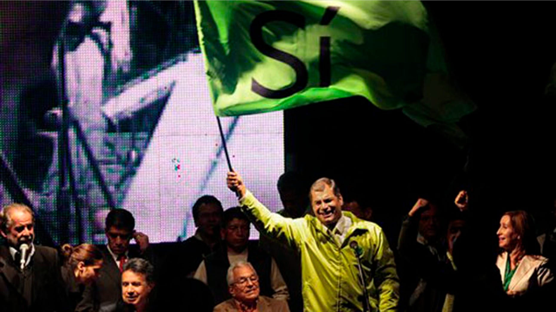 Ecuador's President Rafael Correa, top, accompanied by members of his government and collaborators, waves a flag that reads in Spanish "Yes," during a meeting in Quito, Ecuador, Saturday, May 2011. Correa declared victory after an exit poll indicated voters approved all 10 ballot questions in a referendum Saturday, an outcome critics say will tighten his grip on power, inhibit press freedom and lessen the judiciary's independence. (AP Photo/Dolores Ochoa)