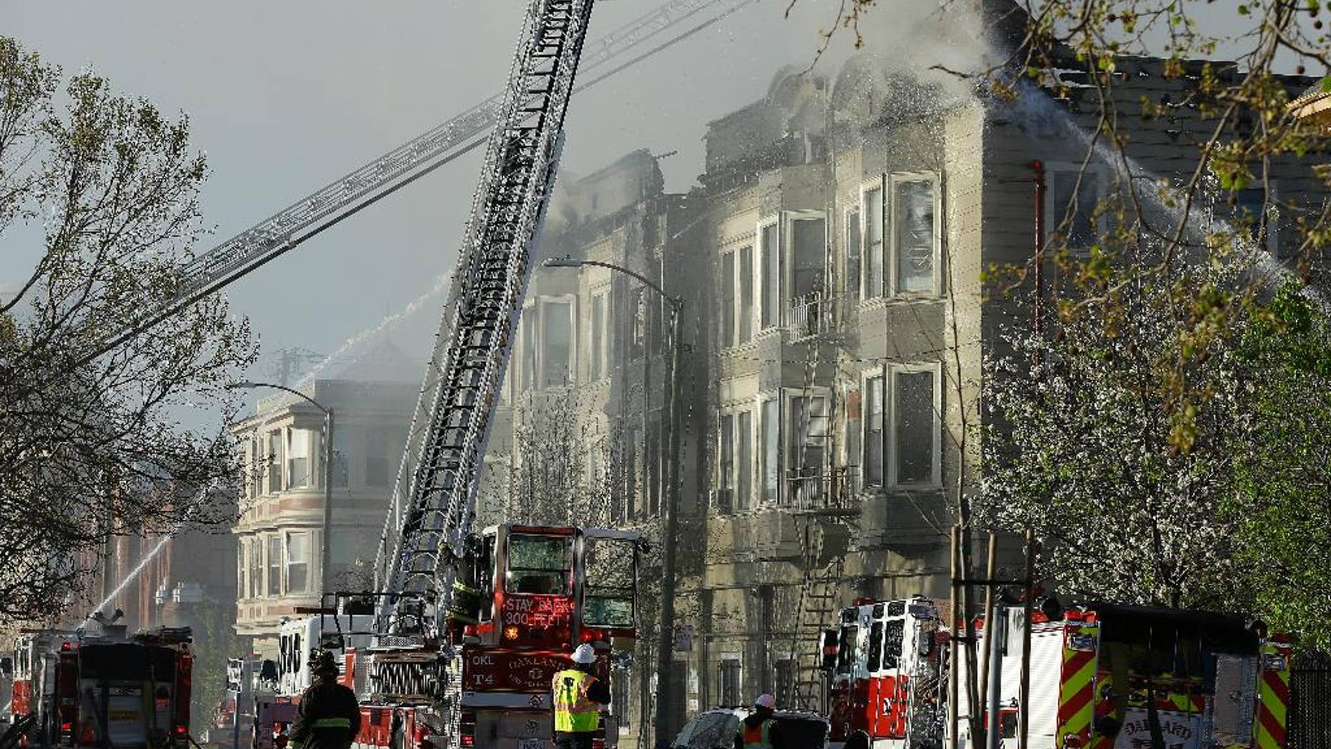 FILE - In this Monday, March 27, 2017 file photo, firefighters battle an early morning apartment fire in Oakland, Calif. Oakland officials say that a burning candle started a deadly building fire that killed four people. The announcement Thursday, March 30, 2017, rules out arson as the cause of a Monday blaze that also displaced dozens of residents in a building for recovering addicts and people who had been homeless. (AP Photo/Ben Margot, File)
