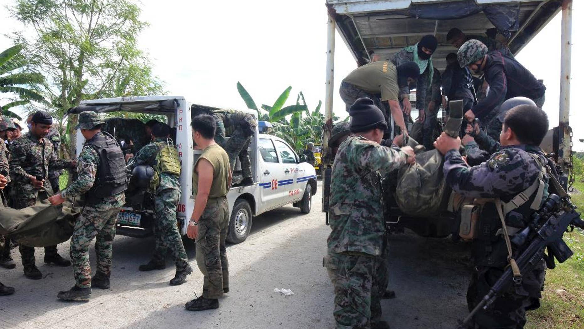 Members of the Philippine National Police Special Action Forces load bodies of police commandos into vehicles in Maguindanao, Philippines, Monday, Jan. 26, 2015. More than 40 Philippine police commandos were killed in a fierce battle with Muslim guerrillas after launching an assault in which they may have killed one of southeast Asia's most-wanted terrorists, officials said Monday. (AP Photo)