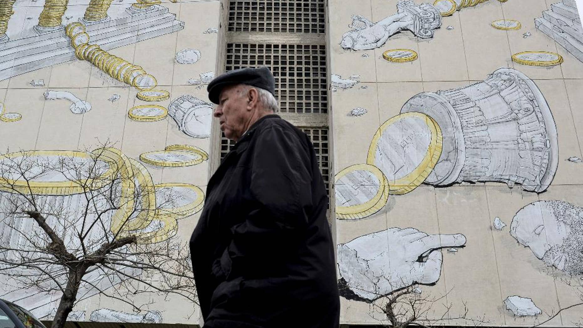 A man walks past a mural in the northern Greek town of Thessaloniki, on Wednesday, March 11, 2015. Greece is quickly running out of cash and has to repay debts this month to the International Monetary Fund — which co-funded Greece's 240 billion euro bailout — as well having as treasury bills coming due. (AP Photo/Giannis Papanikos)
