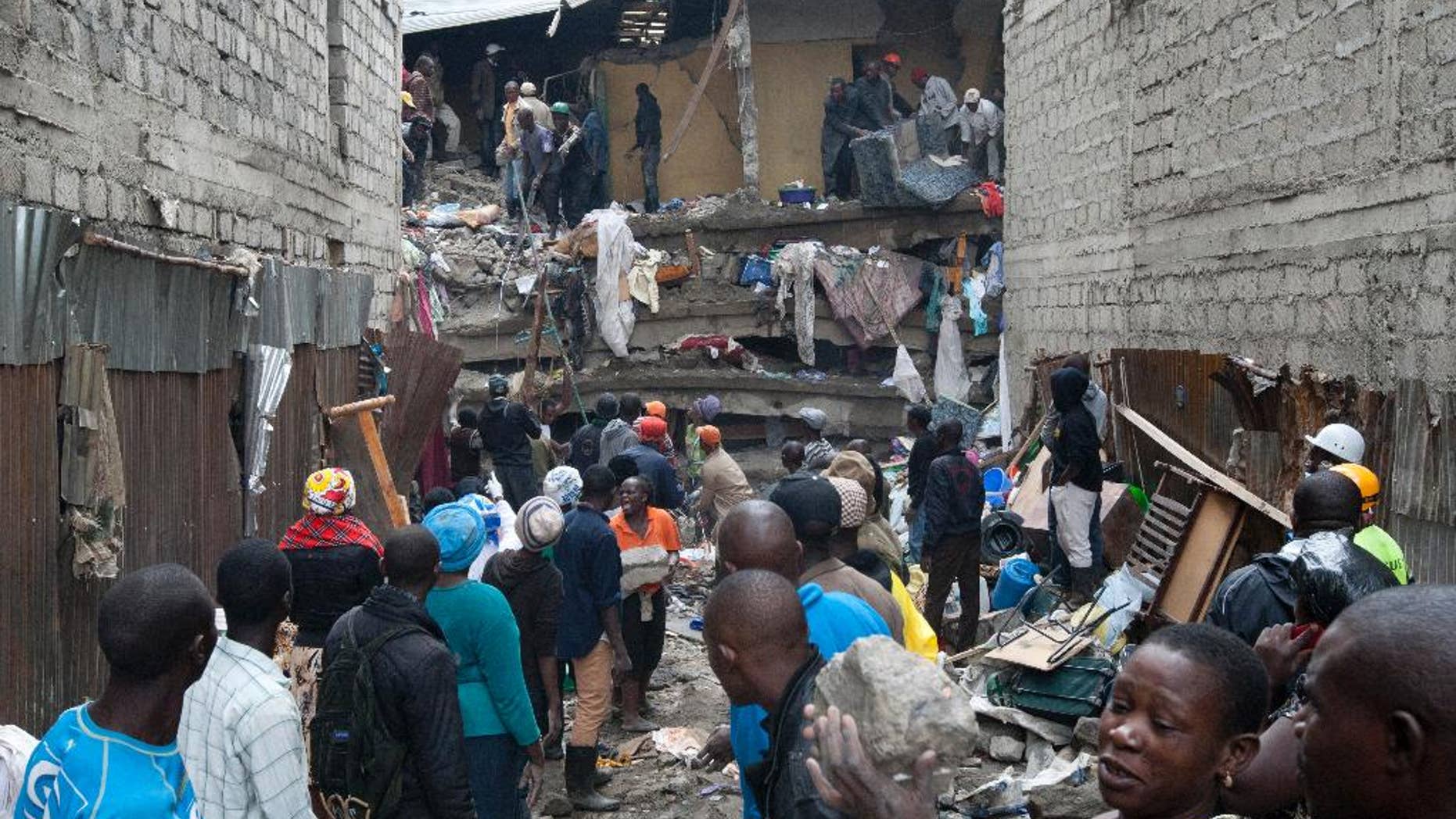 People help survivors retrieve their household items at the site of a building collapse in Nairobi, Kenya, Saturday, April 30, 2016. A six-storey residential building in a low income area of the Kenyan capital collapsed Friday night under heavy rain and flooding, killing at least seven people and injuring over 100 others, Kenyan officials said. (AP Photo/Sayyid Abdul Azim)