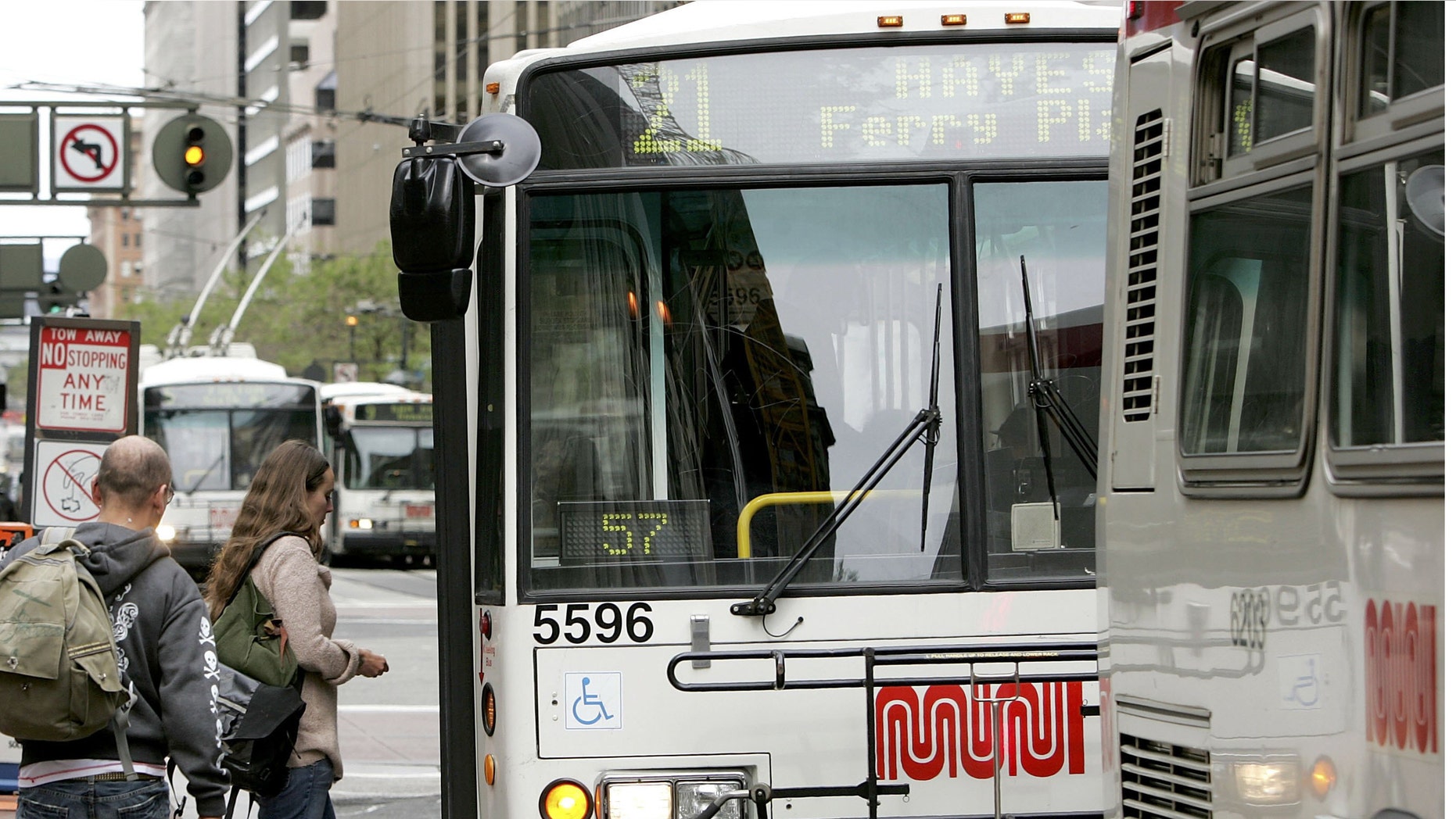 Passengers board a MUNI bus along Market Street in San Francisco, California.
