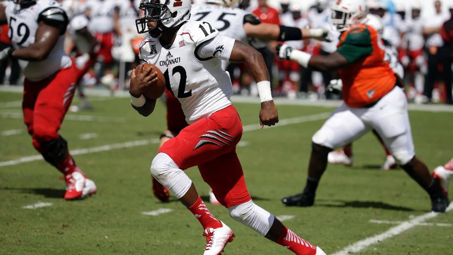 FILE - In this Oct. 11, 2014, file photo, Cincinnati quarterback Jarred Evans (12) runs in the second half of an NCAA college football game against Miami in Miami Gardens, Fla. Hamilton County Jail records show 22-year-old Jarred Evans was booked just before 4 a.m. Sunday, Oct. 19, 2014, on a misdemeanor assault charge. Police said Evans knocked a man down with a punch that caused a concussion and cuts requiring stitches. (AP Photo/Lynne Sladky, File)