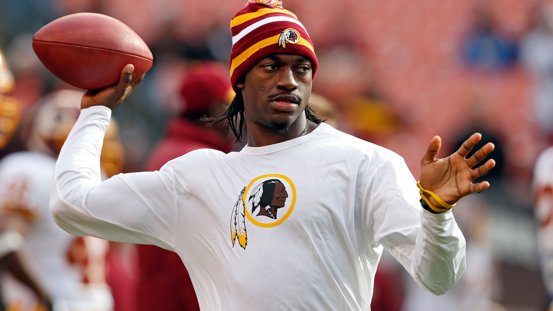 Washington Redskins quarterback Robert Griffin III tosses a ball during warmups before an NFL football game against the Cleveland Browns in Cleveland, Sunday, Dec. 16, 2012. Kirk Cousins will start in place of Griffin wgho is sitting out with a sprained knee. (AP Photo/Rick Osentoski)