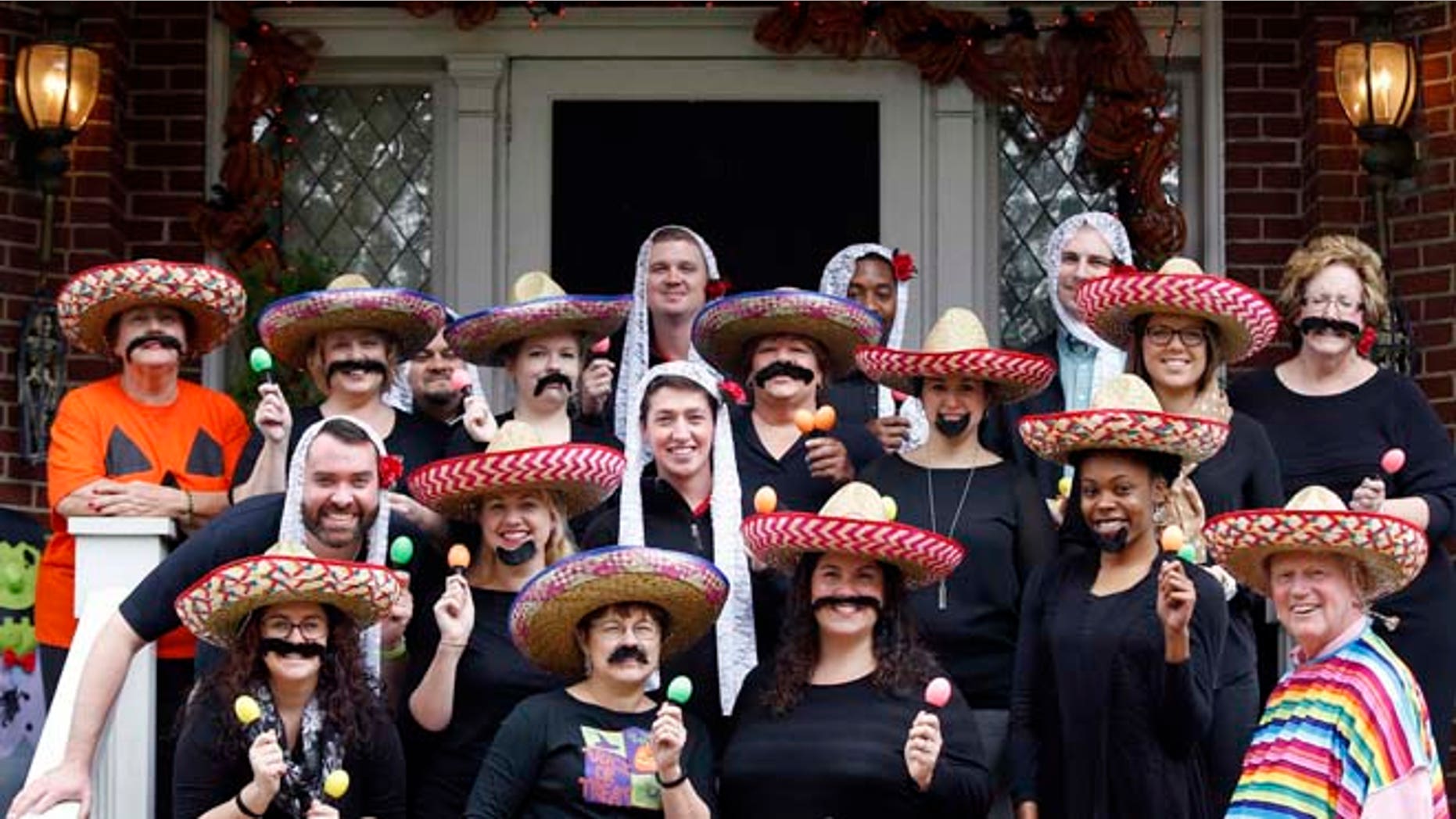 In this Oct. 28, 2015 photo, University of Louisville James Ramsey, lower right, and his wife, Jane, upper left, host a Halloween party in Louisville, Ky. The University of Louisville has apologized after the photo surfaced showing Ramsey among staffers dressed in stereotypical Mexican costumes. (Scott Utterback/The Courier-Journal via AP) NO SALES; MAGS OUT; NO ARCHIVE; MANDATORY CREDIT