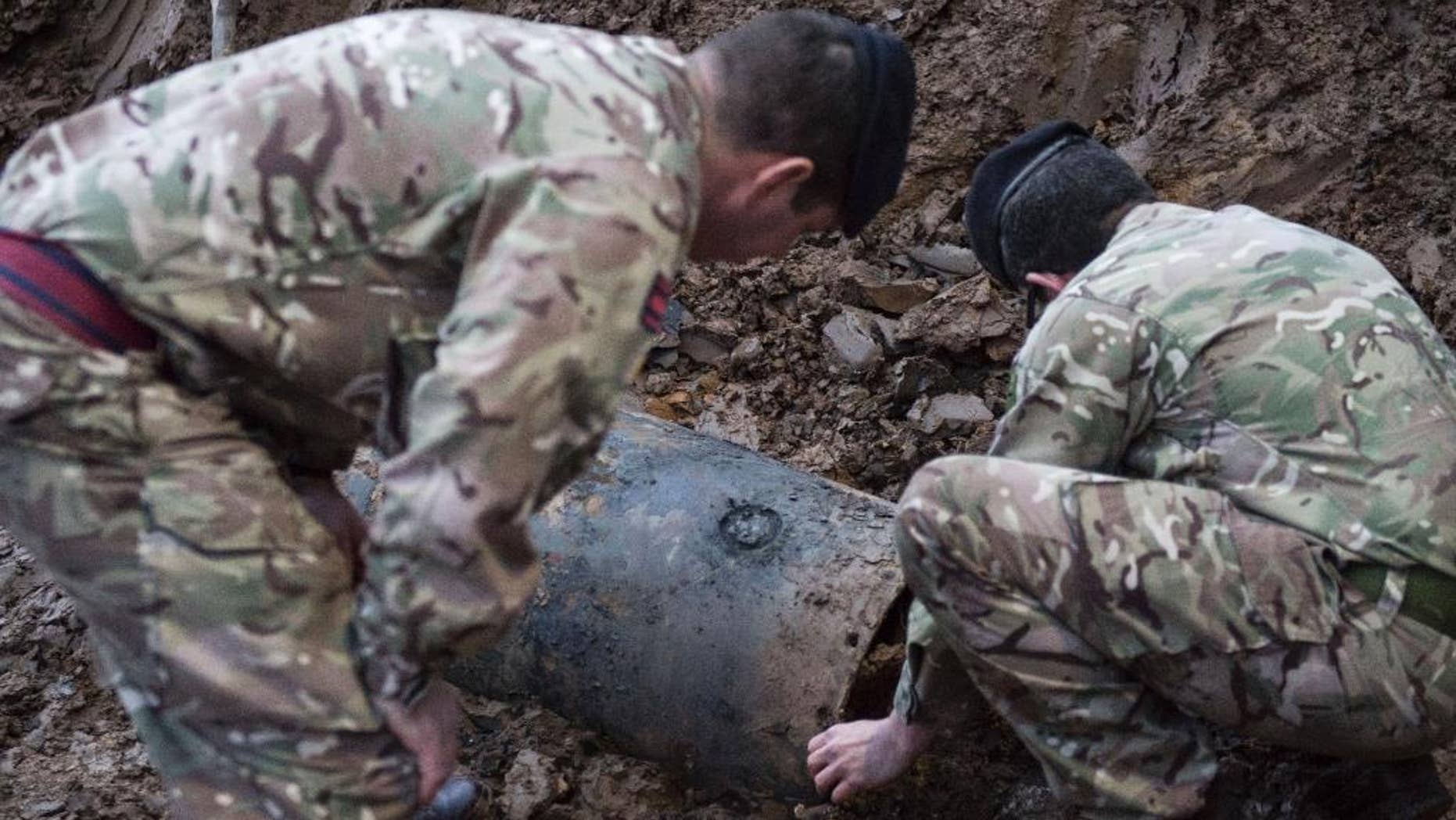 In this image taken Thursday March 2, 2017 released by the Ministry of Defence shows a Second World War bomb which was discovered on a building site in Brent, north-west London. British Army bomb disposal team were called in to dispose of a 500-pound World War II bomb found buried on a building site in northwest London. Schools, businesses and homes were evacuated and roads closed as experts from the Army's Royal Engineers to make the German bomb safe. (Rupert Frere/MoD via AP)
