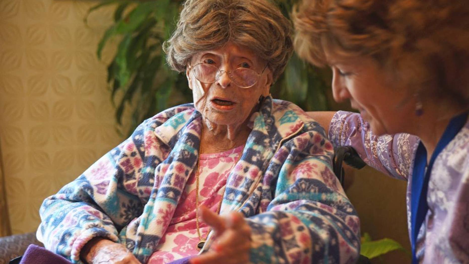 In this July 19, 2016, file photo, 113-year-old Adele Dunlap, left, talks with Susan Dempster, right, the activities director at the Country Arch Care Center in Pittstown, N.J.