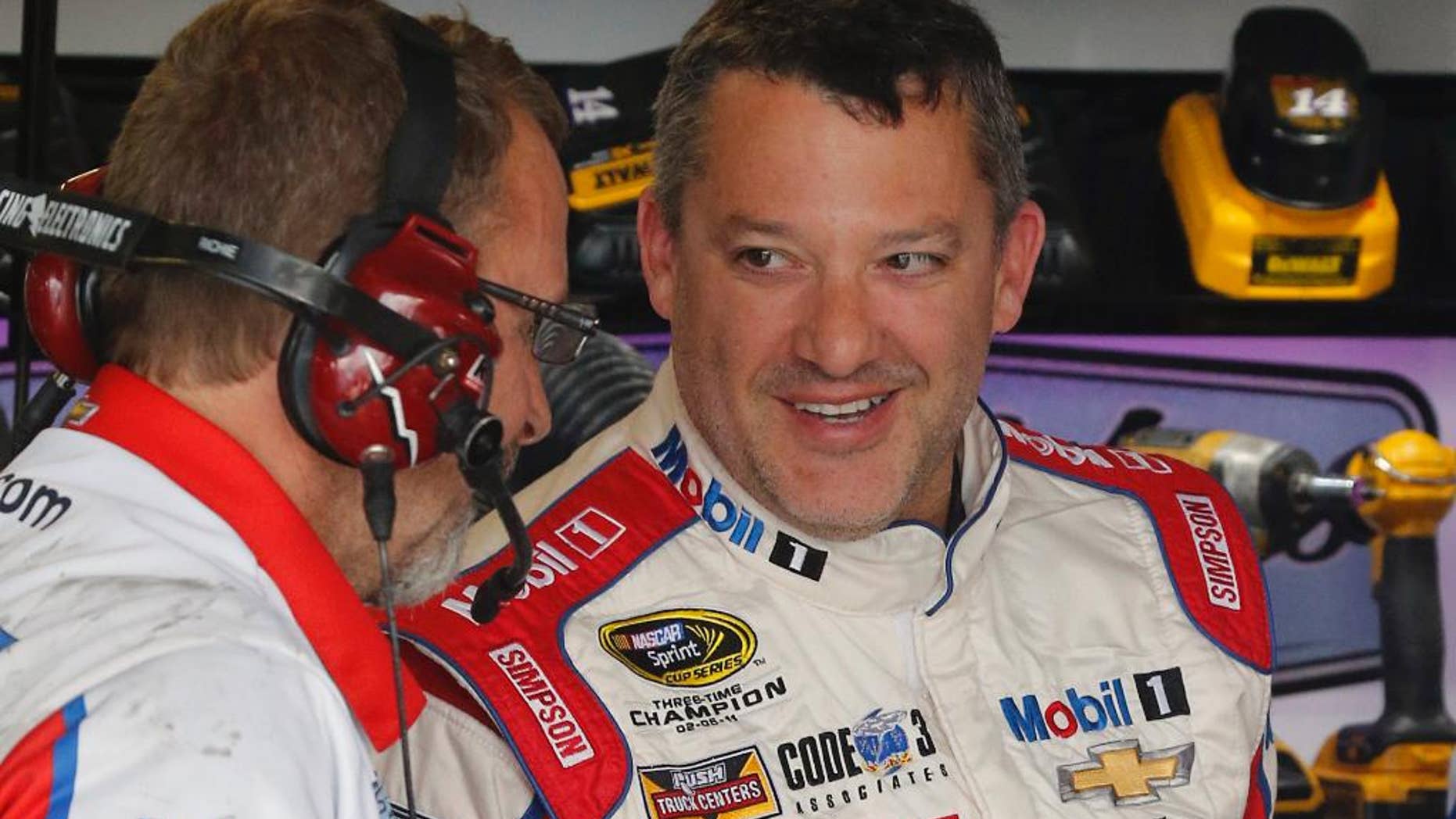 FILE - In this April 22, 2016, file photo, Tony Stewart, right, jokes with a crew member during practice for a NASCAR Sprint Cup auto race at Richmond International Raceway in Richmond, Va. Now that he's got his first victory in over three years, Stewart is able to realistically set some goals for his final season as a NASCAR driver. First up: Cross Kentucky Speedway off the list of active tracks where he's never won. (AP Photo/Steve Helber, File)