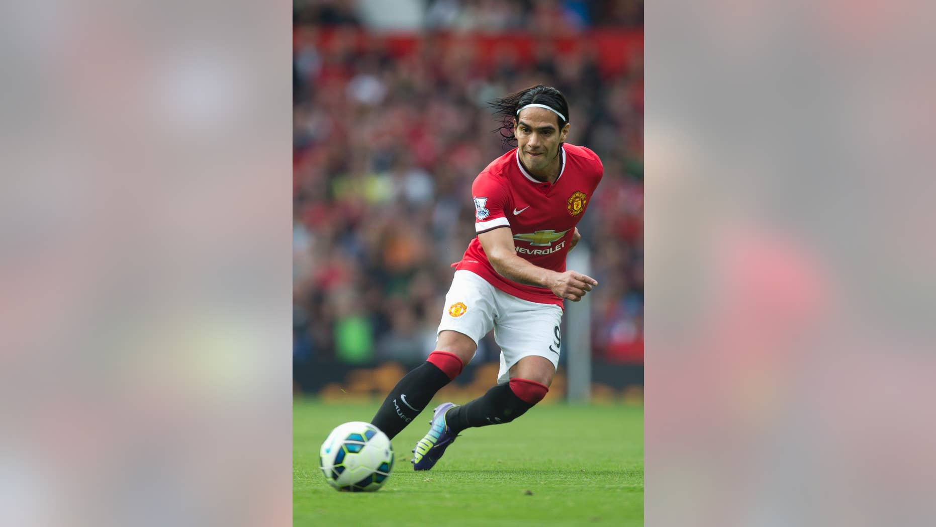 Manchester United's Radamel Falcao Garcia passes the ball up field during his team's English Premier League soccer match against West Ham United at Old Trafford Stadium, Manchester, England, Saturday Sept. 27, 2014. (AP Photo/Jon Super)