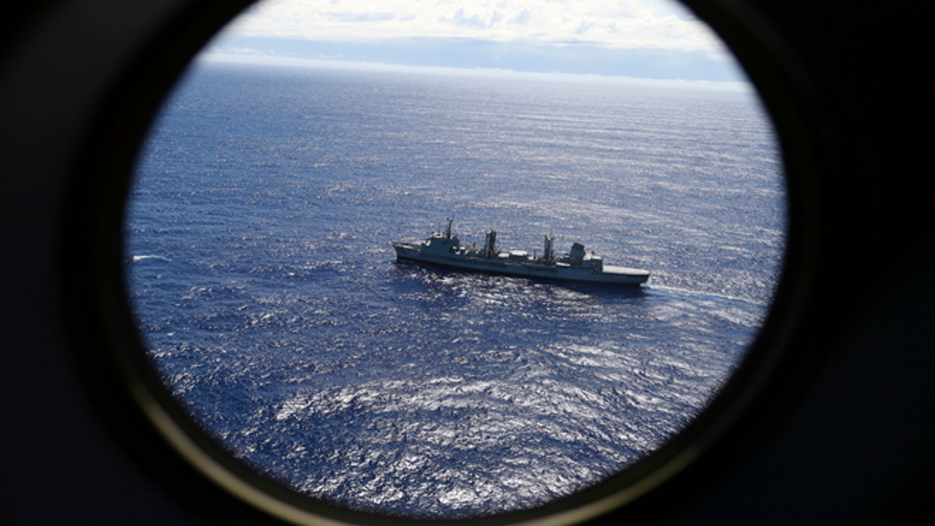 FILE - In this March 31, 2014, file photo, HMAS Success scans the southern Indian Ocean, near the coast of Western Australia, as a Royal New Zealand Air Force P3 Orion flies over, while searching for missing Malaysia Airlines Flight MH370.