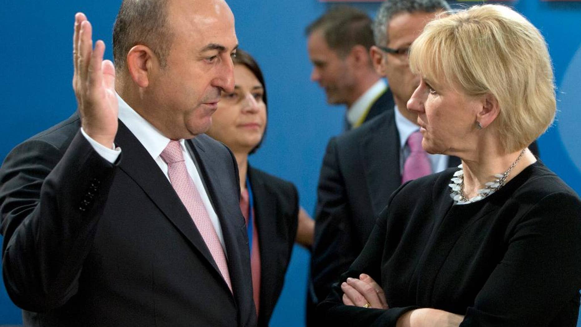 FILE- In this Friday, May 20, 2016 file photo, Turkish Foreign Minister Mevlut Cavusoglu, left, speaks with Swedish Foreign Minister Margot Wallstrom during a meeting of the North Atlantic Council at NATO headquarters in Brussels. Turkey has summoned on Monday, Aug. 15, 2016, officials from Austria and Sweden to protest against news reports and Twitter comments in the two countries relating to a Turkish Constitutional Court ruling on child abuse. (AP Photo/Virginia Mayo, File)