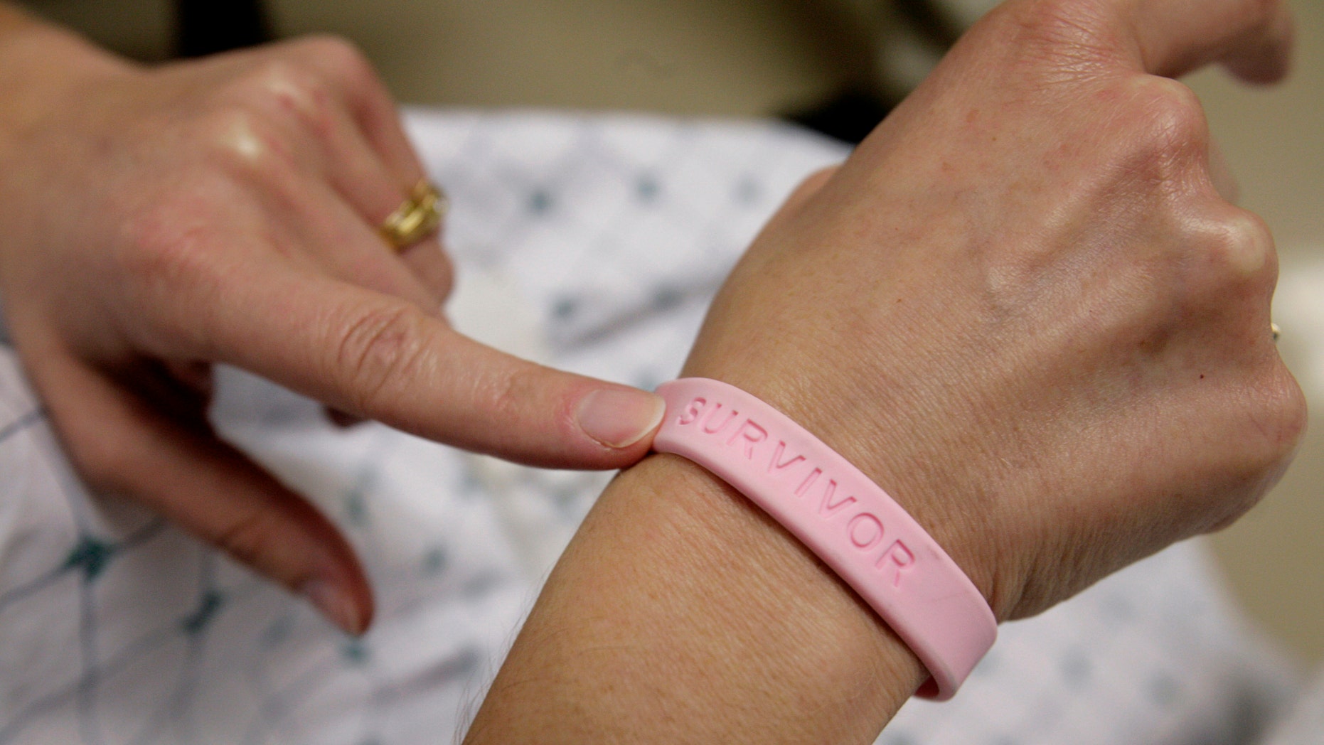 A cancer patient shows off her breast cancer survivor bracelet. (REUTERS/Jim Bourg)