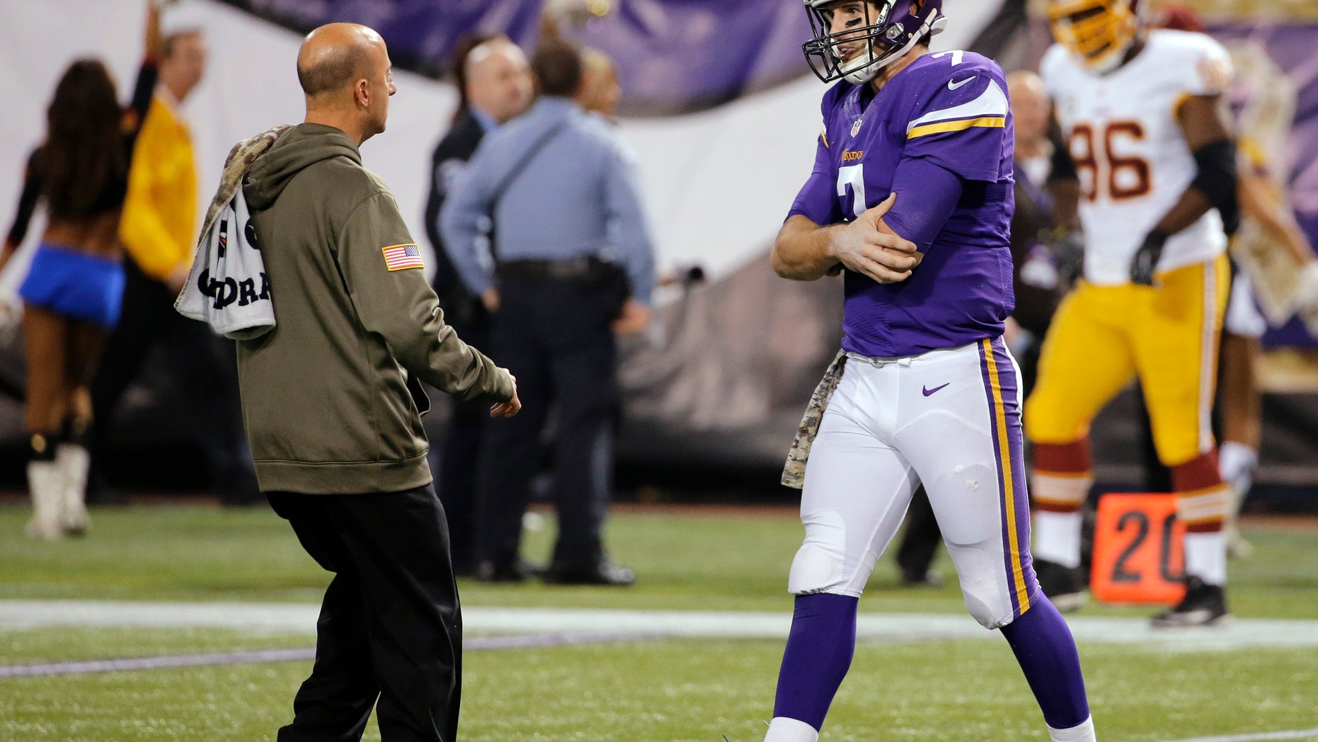 Minnesota Vikings quarterback Christian Ponder, right, is attended to by a trainer after an injury to his left shoulder during the second half of an NFL football game against the Washington Redskins, Thursday, Nov. 7, 2013, in Minneapolis. (AP Photo/Ann Heisenfelt)