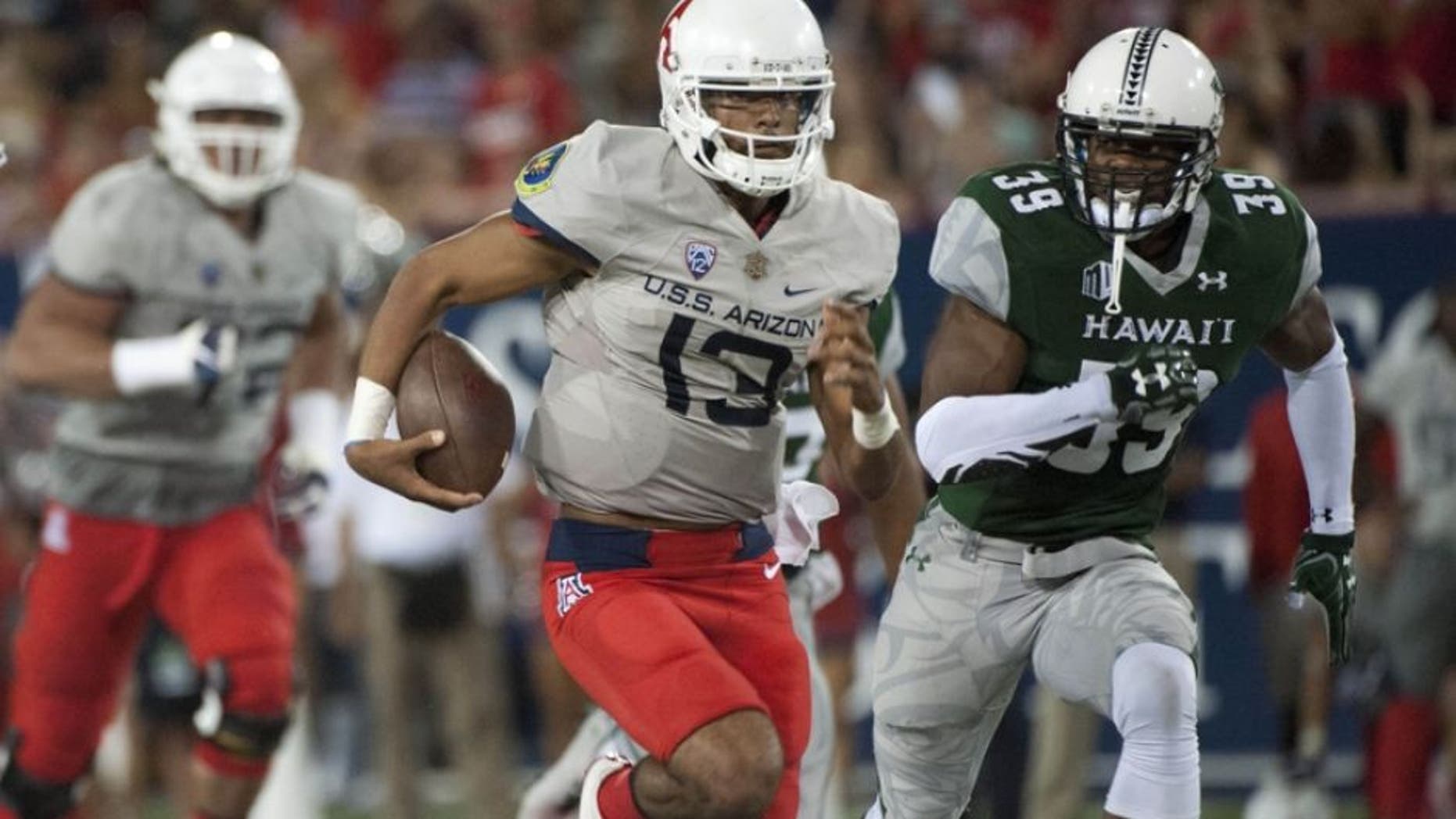 Sep 17, 2016; Tucson, AZ, USA; Arizona Wildcats quarterback Brandon Dawkins (13) runs the ball under pressure from Hawaii Warriors defensive back Trayvon Henderson (39) during the second quarter at Arizona Stadium. Mandatory Credit: Casey Sapio-USA TODAY Sports