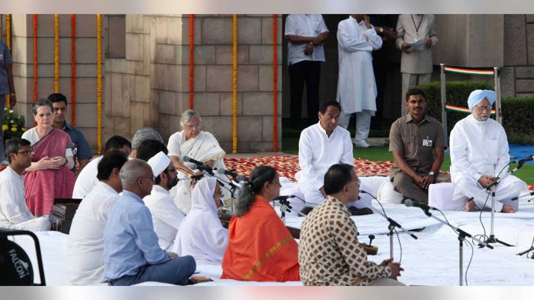 Chairperson of the Congress-led UPA government, Sonia Gandhi (L) and Indian Prime Minister Manmohan Singh (R) paying their respects at the memorial to the Father of the Nation Mahatma Gandhi at Rajghat in New Delhi on October 2, 2013