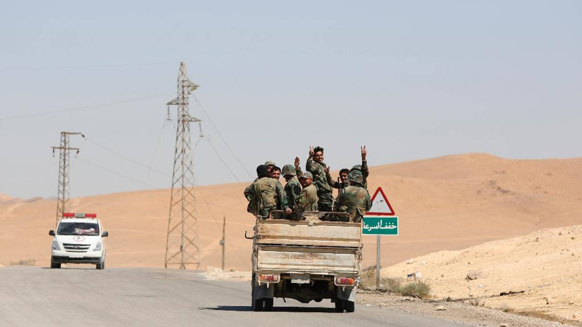 Syrian soldiers flash the v-victory sign in the ancient city of Palmyra on Friday, April 2, 2016. An Associated Press crew visiting the town Friday witnessed firsthand the destruction inflicted by the extremist group on the town’s famed archaeological site, less than a mile away from the modern-day town of the same name, now completely deserted. (AP Photo)