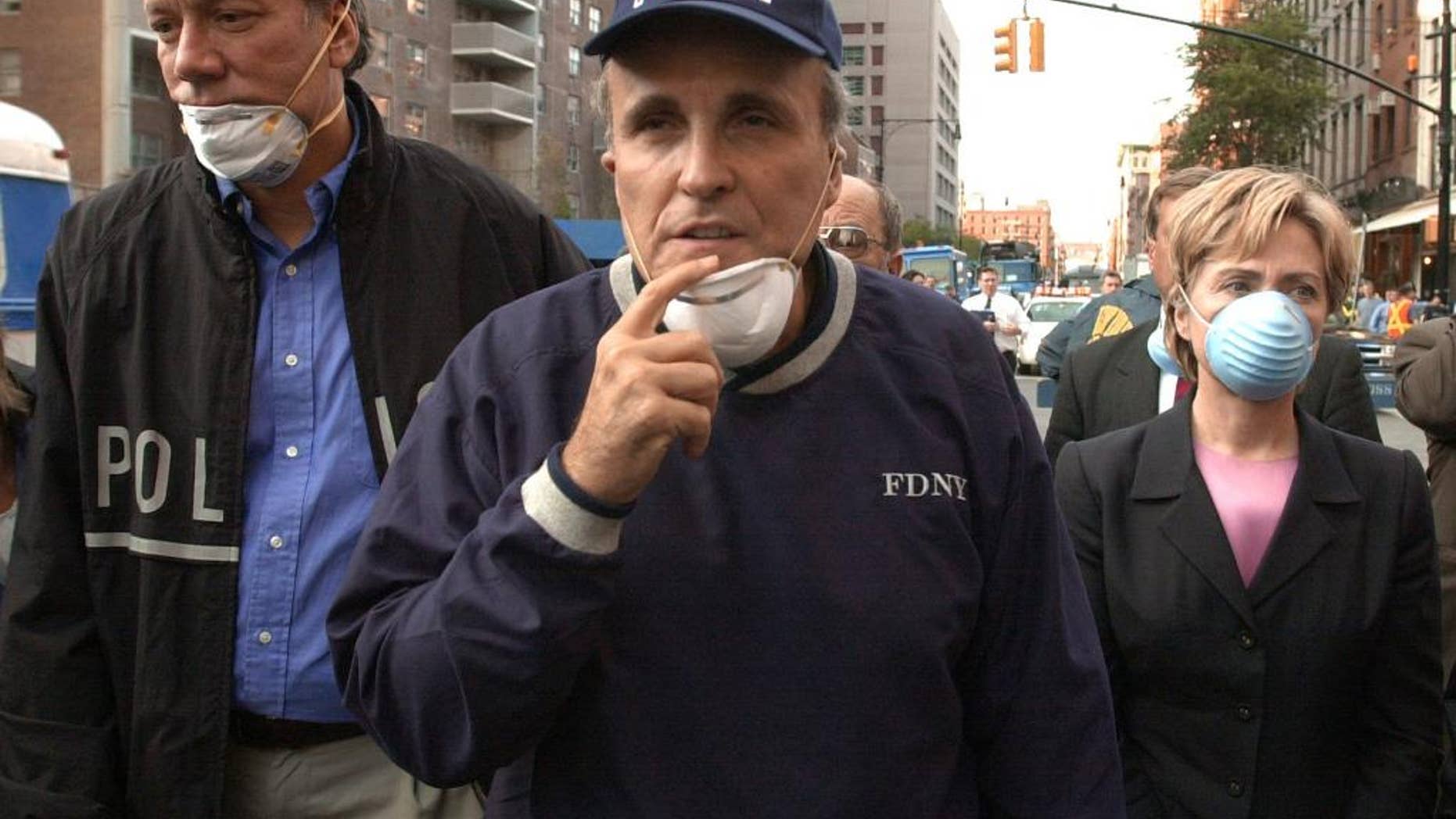 FILE - In this Wednesday, Sept. 12, 2001 file photo, New York City Mayor Rudolph Giuliani, center, leads New York Gov. George Pataki, left, and Sen. Hillary Clinton, D-N.Y., on a tour of the site of the World Trade Center disaster. While stumping for Donald Trump in Ocala, Fla., on Oct. 12, 2016, former New York City Mayor Rudy Giuliani accused Hillary Clinton of falsely claiming to have been in New York on Sept. 11, 2001. It isn’t clear what Giuliani was talking about. On many occasions, Clinton has described being in Washington, where Congress was in session, on Sept. 11 when hijacked jets began striking the World Trade Center and the Pentagon. Flights were still grounded on Sept. 12, 2001, but Clinton traveled to New York City the next day aboard a federal plane. There, she circled the smoldering World Trade Center in a helicopter, then toured ground zero with Giuliani and Pataki. (AP Photo/Robert F. Bukaty, File)