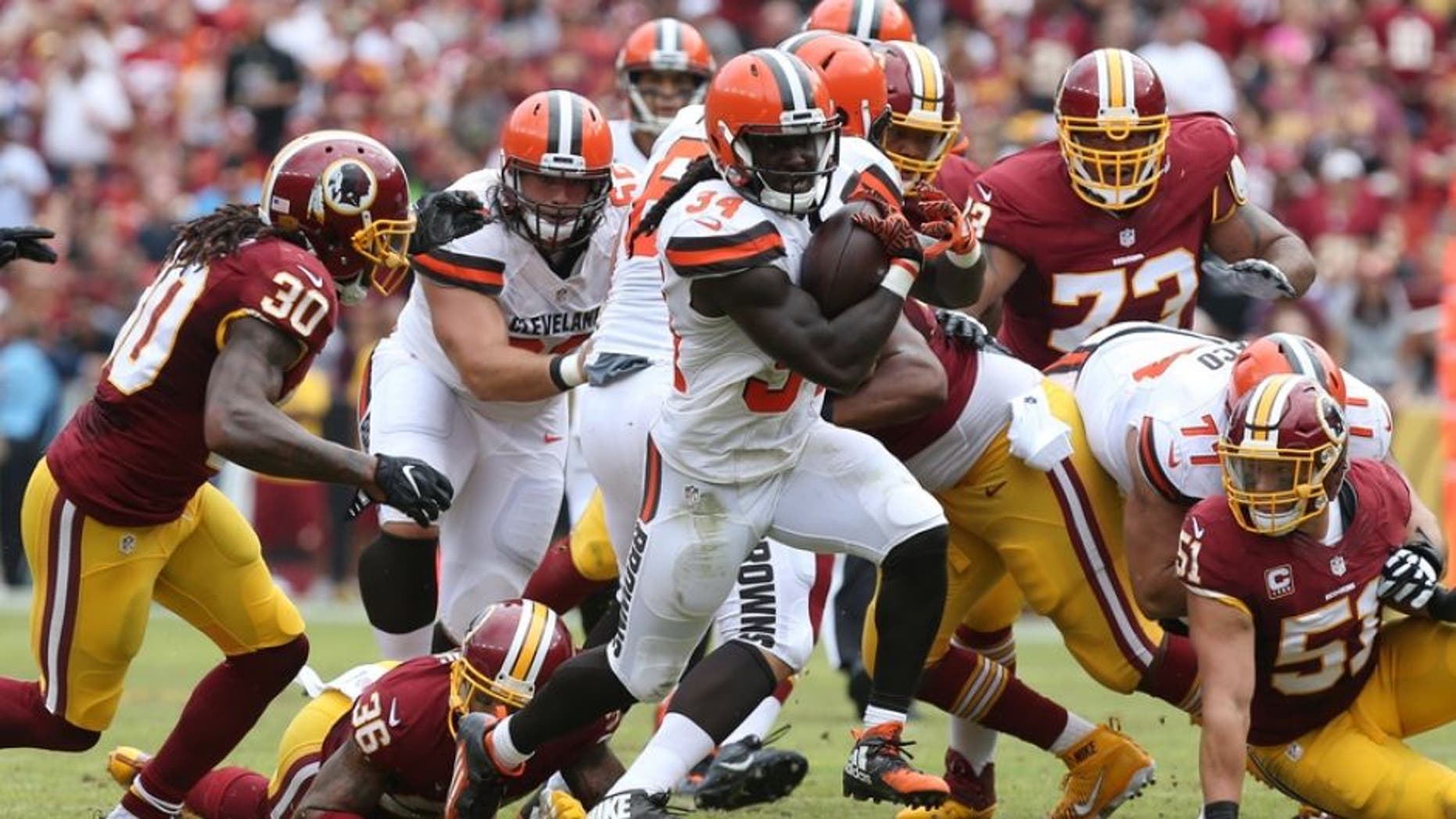 Oct 2, 2016; Landover, MD, USA; Cleveland Browns running back Isaiah Crowell (34) carries the ball past Washington Redskins safety David Bruton Jr. (30) and Redskins linebacker Will Compton (51) in the second quarter at FedEx Field. Mandatory Credit: Geoff Burke-USA TODAY Sports