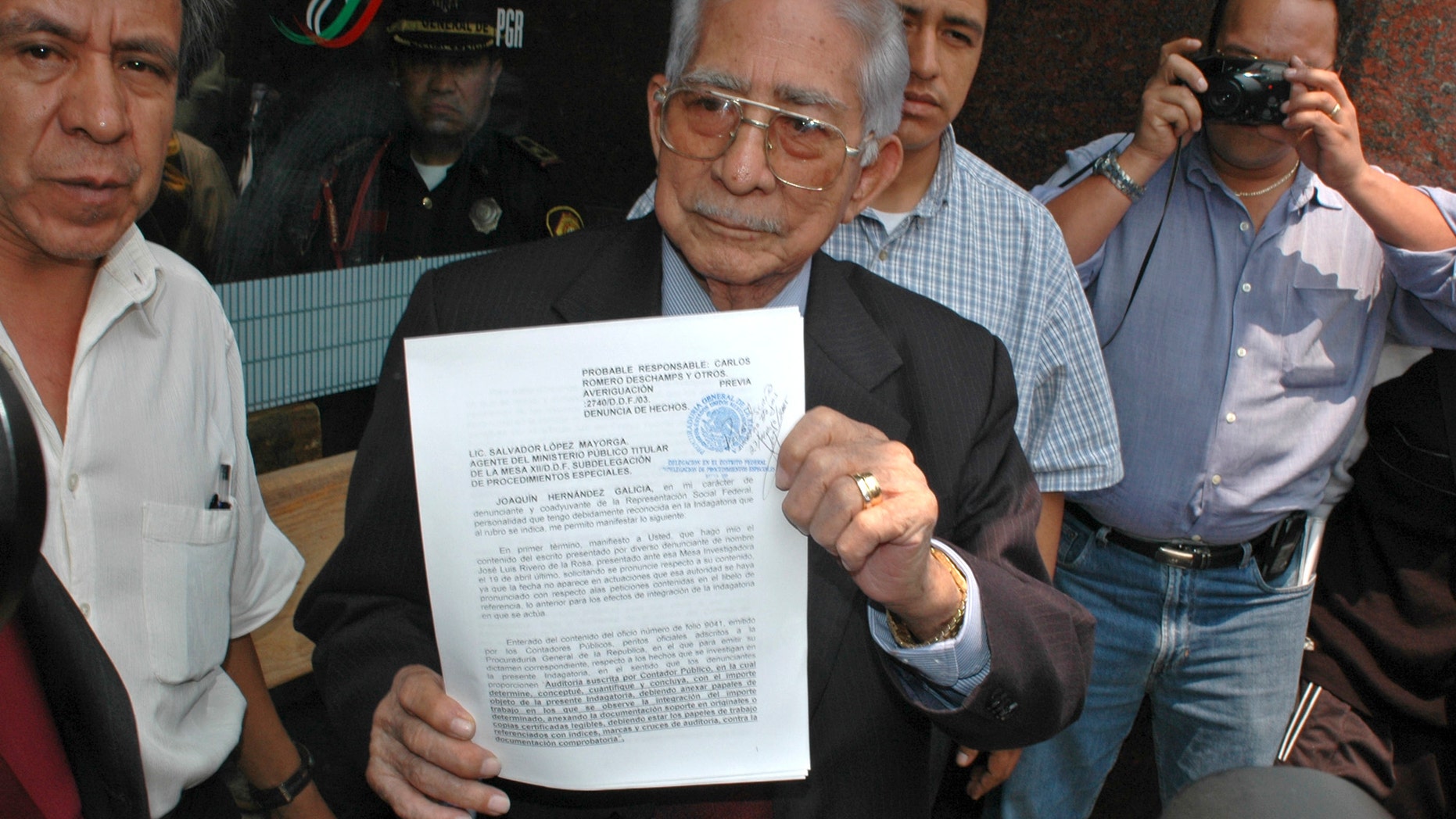 FILE - In this May 27, 2005 file photo, the former boss of Mexico's powerful oil workers union, Joaquin Hernandez Galicia, holds up a lawsuit on corruption charges he filed against the current union boss of Pemex outside a courthouse in Mexico City. Hernandez was an old-style Mexican labor leader who became one of the country's most powerful and wealthiest men through patronage, corruption and strong-arm tactics. A son of the once-feared boss says Hernandez, known as "La Quina," has died after spending several days in a hospital in the northern city of Tampico for stomach problems. He was 91. (AP Photo/Roberto Velazquez, File)
