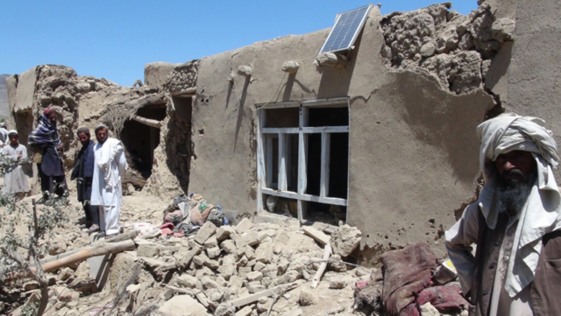 June 6, 2012: Afghan villagers gather near a house destroyed in an apparent NATO raid in Logar province, south of Kabul, Afghanistan.