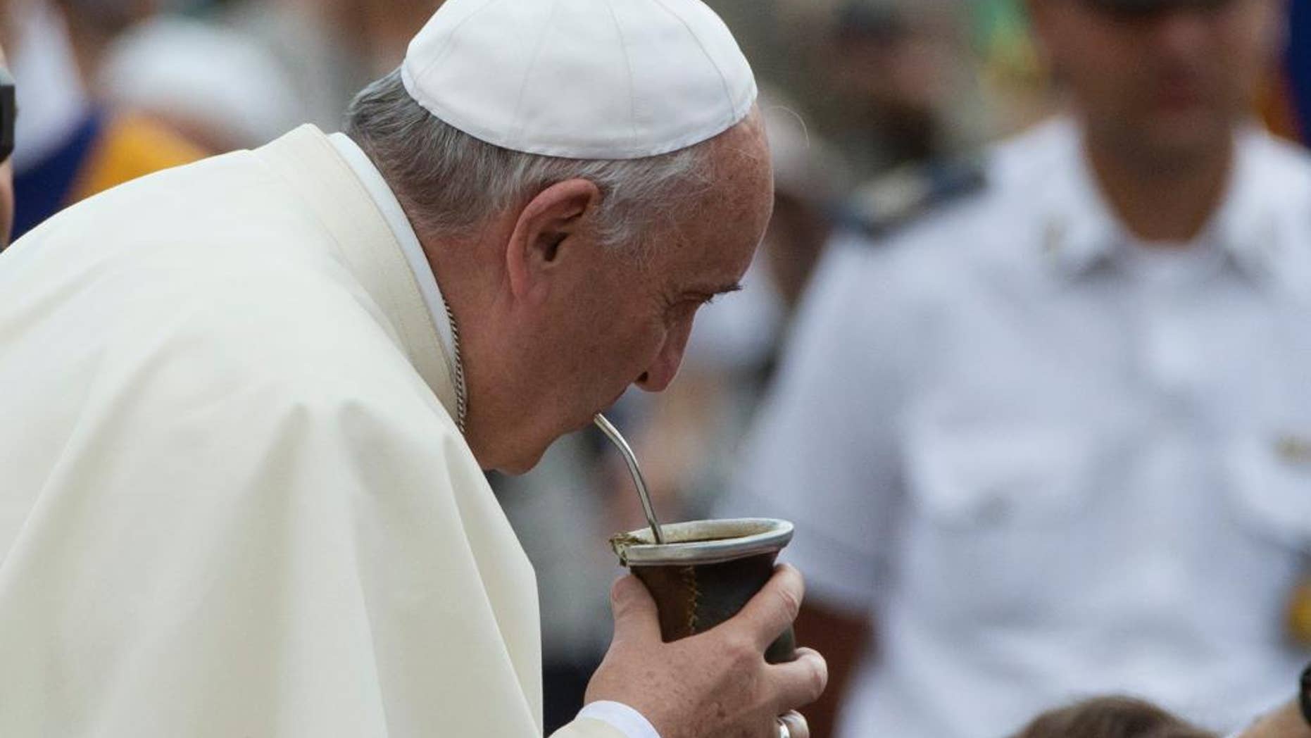 Pope Francis drinks from a mate gourd, a traditional South American cup, he was offered as he arrived for his weekly general audience, in St. Peter's Square, at the Vatican, Wednesday, Sept. 17, 2014. (AP Photo/Andrew Medichini)