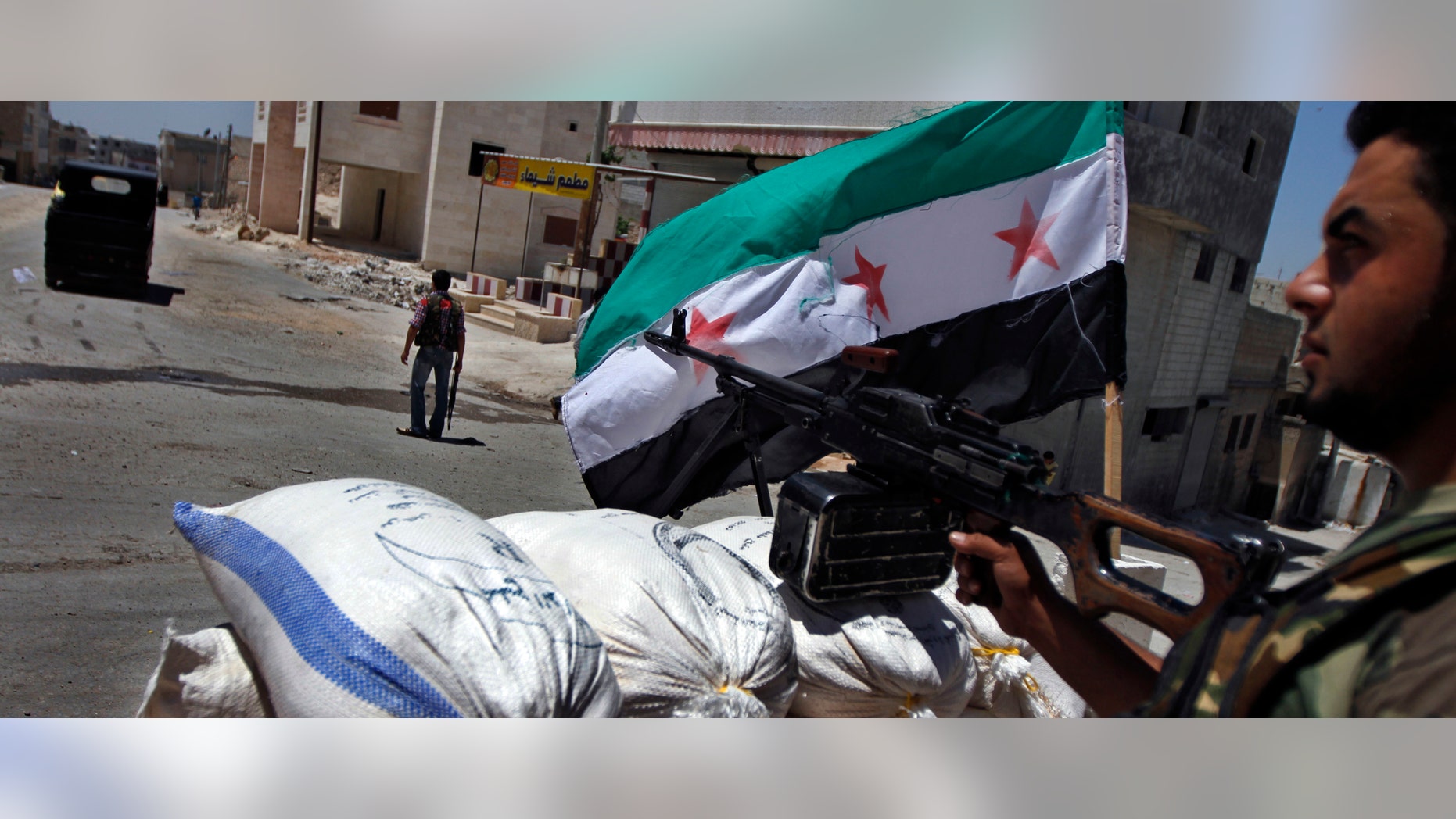 FILE: June 10, 2012: A Free Syrian Army solider aims his weapon at a checkpoint in the northern town of Ariha, on the outskirts of Idlib, Syria.