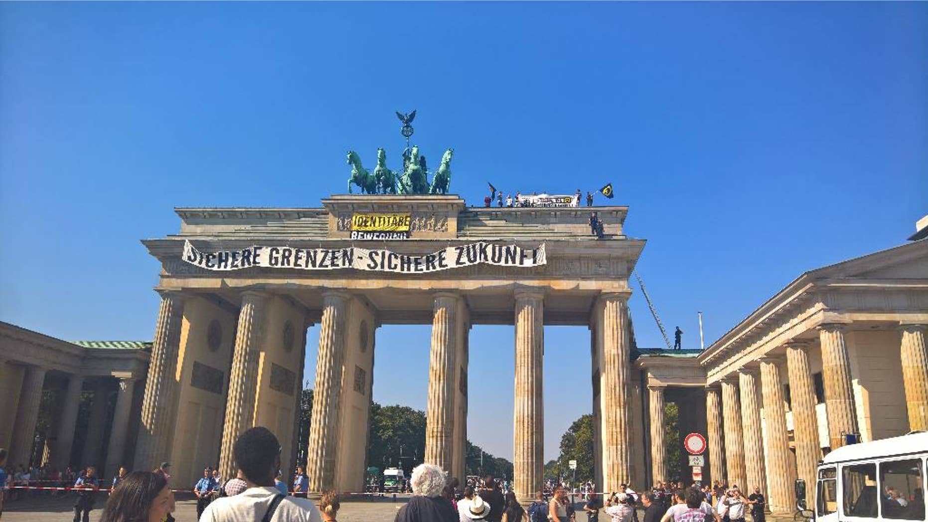 Anti-Islam activists have staged an hour-long demonstration atop Berlin’s Brandenburg Gate Saturday Aug. 27, 2016. The protesters unfurled a banner calling for “secure borders” in Germany. Police said 15 people were briefly detained over the protest and are likely to face charges of trespassing, harassment and breaching laws on public assembly Banner reads : Secure Borders - Secure Future. (AP Photo Frank Jordans)